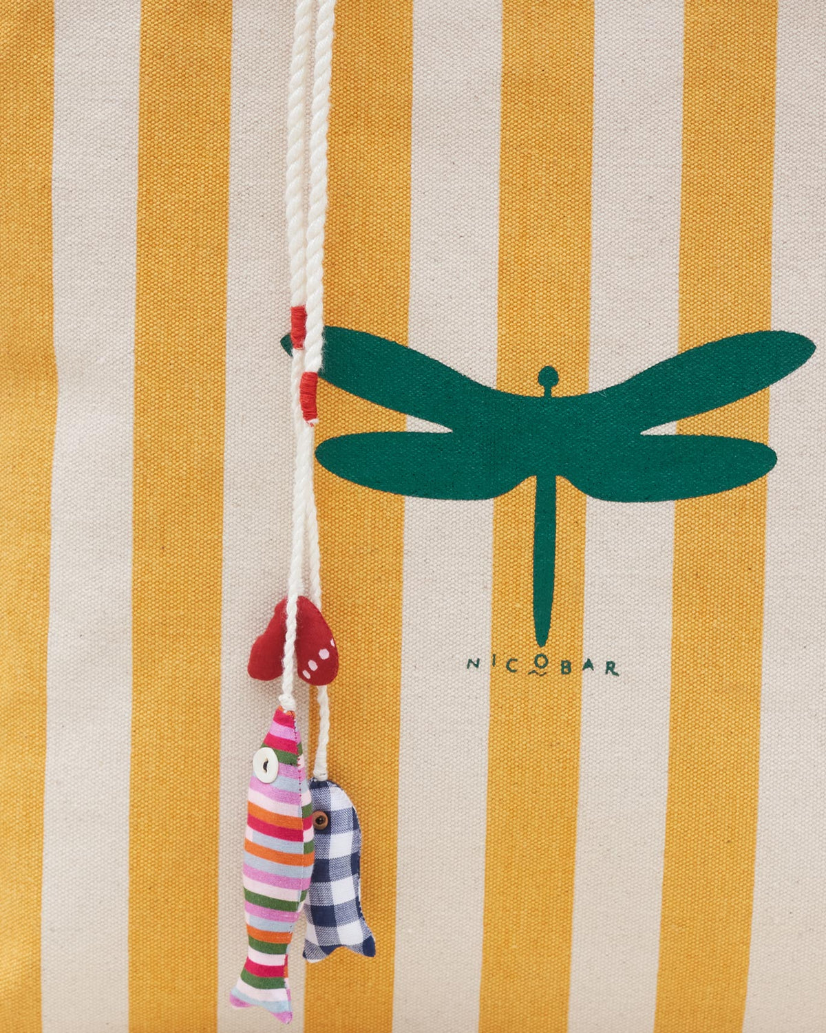 Close-up of a Bagan Stripe Tote showing a green dragonfly print and fabric charms.