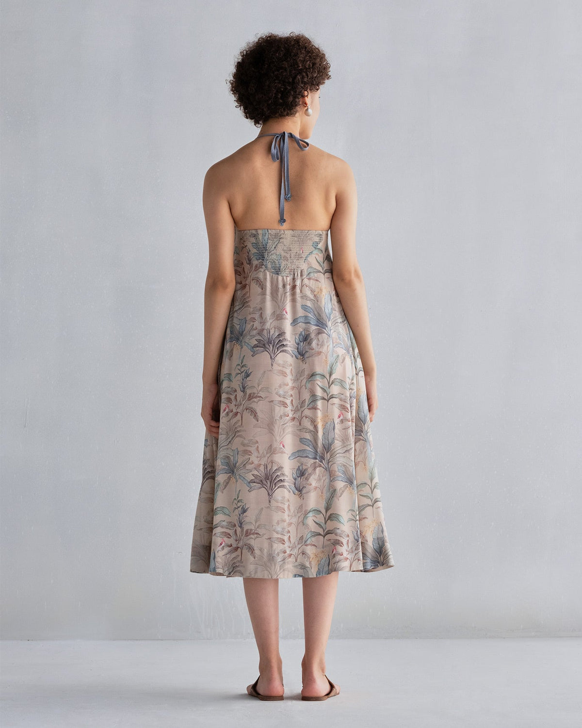Back of Safar Dress with a smocked bodice and halter tie, worn by a person.
