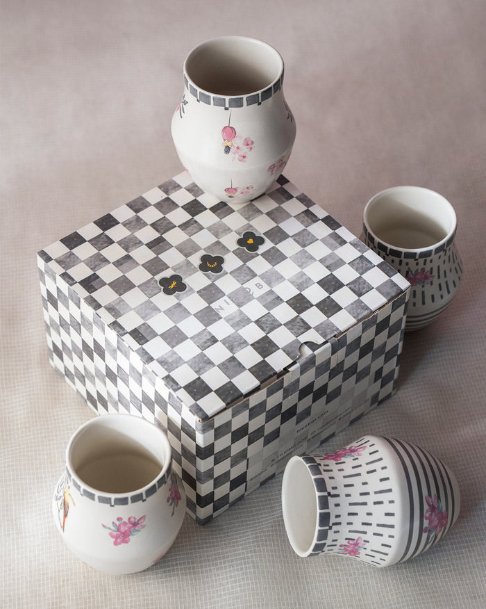 Nectar Kulhars around a black and white checkered gift box.