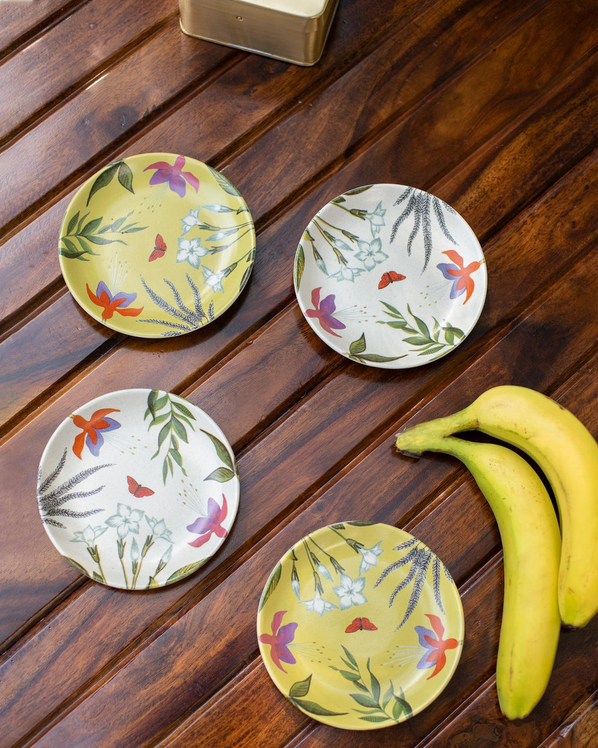 Set of Botanical tea plates with floral prints on cream and yellow.