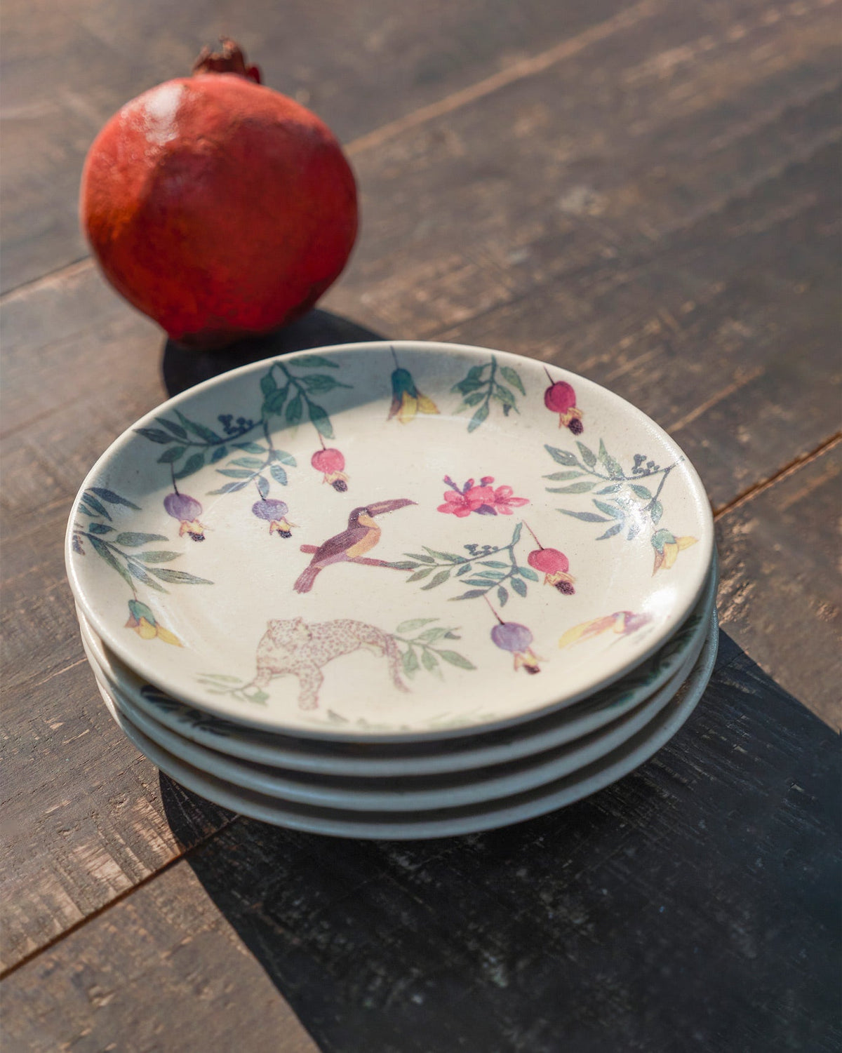 Stack of Nakano tapas plates with toucan, leopard, and flower print on top.