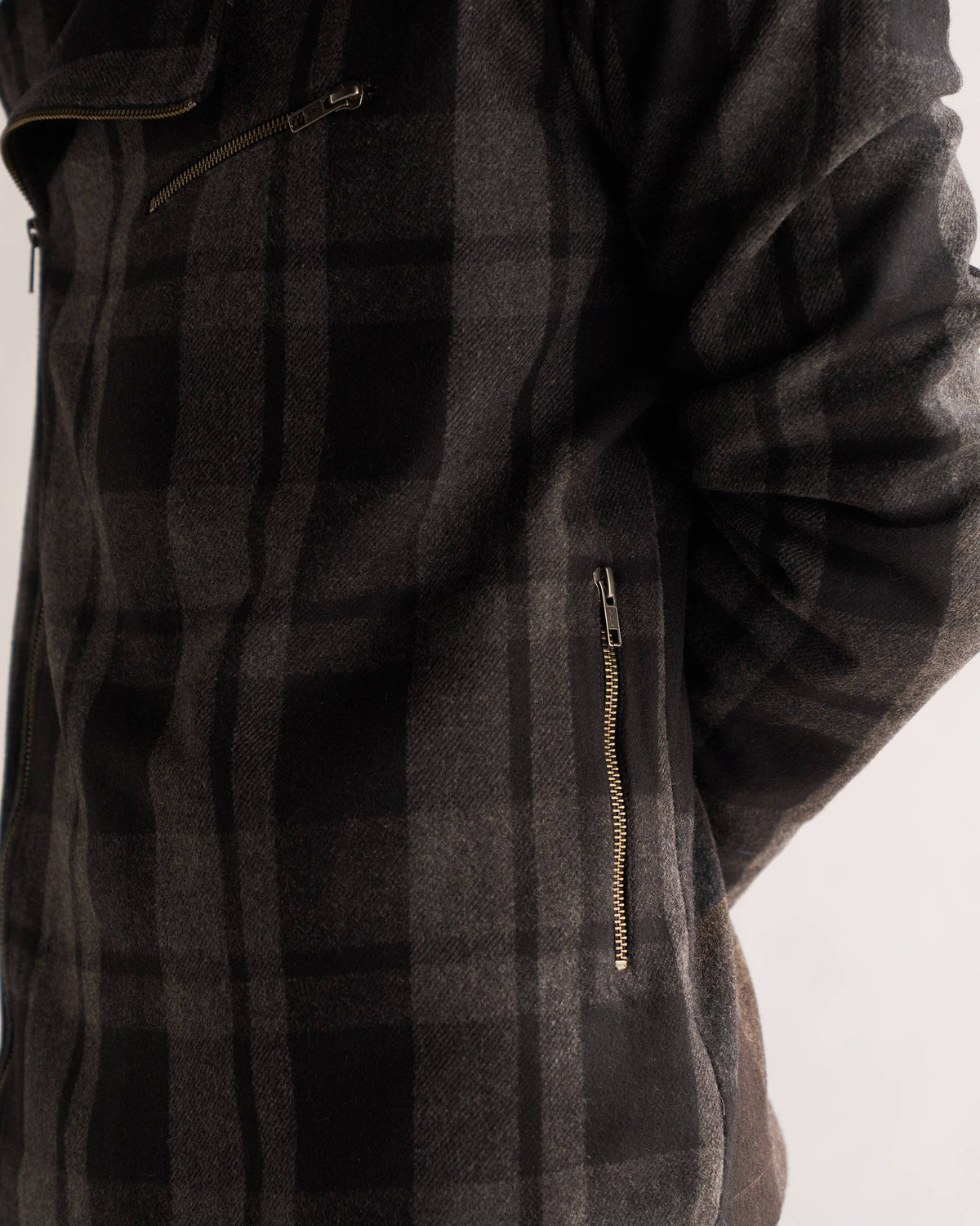 Close-up of a black and grey checked Woollen Knotch Collar Jacket showing a zipped side pocket.