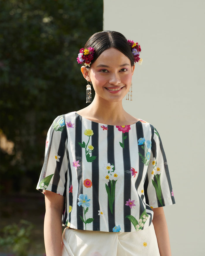 Person wearing a black and white striped Boat Neck Blouse with flower prints.