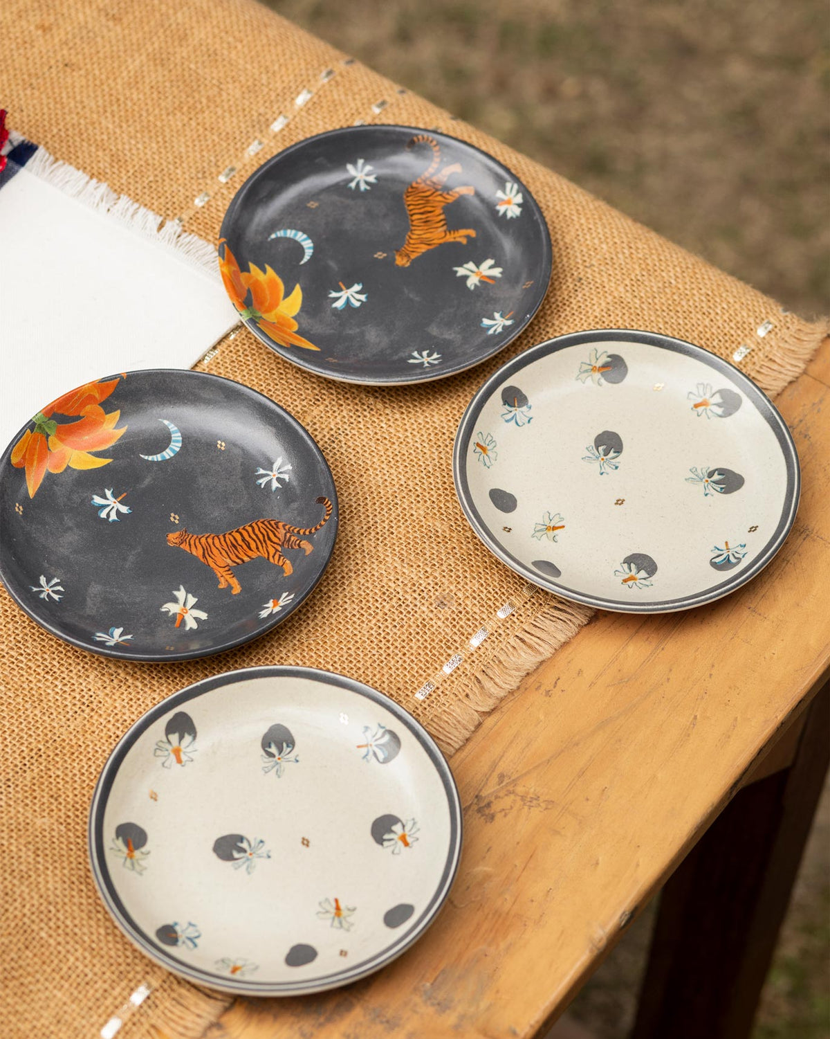 Set of four Nadi tea plates with tiger and dot motifs.