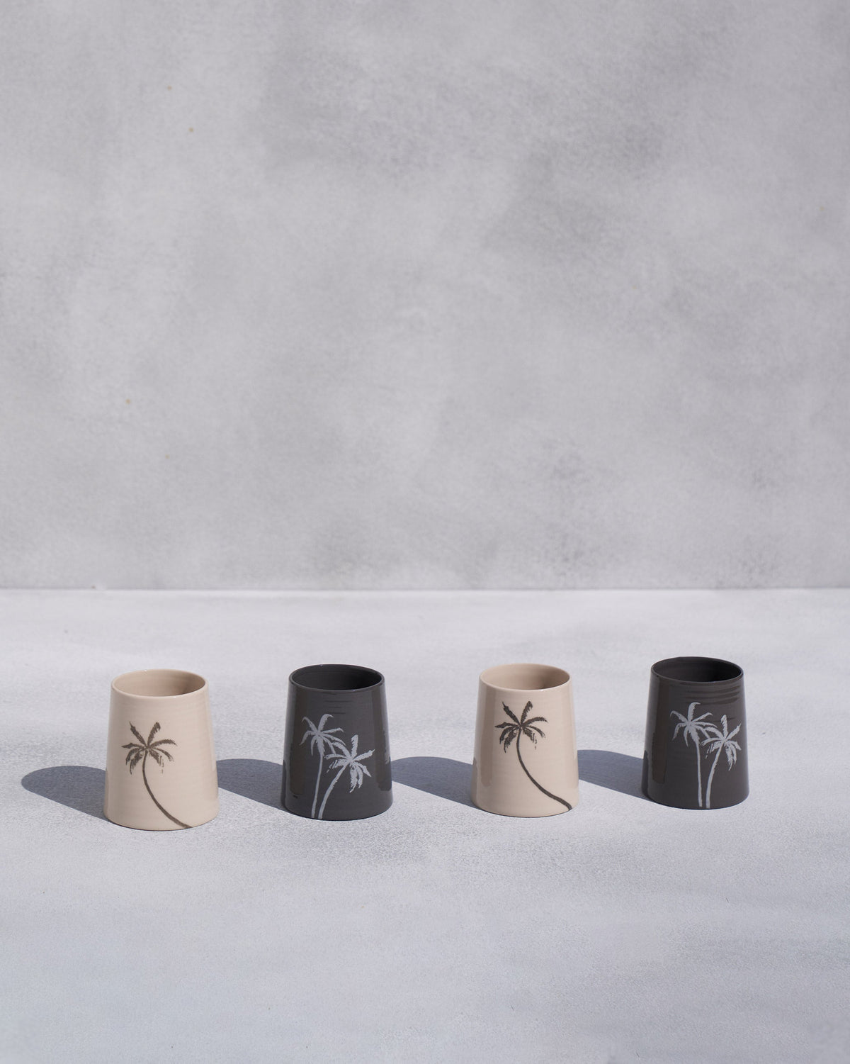 Four Swaying Palm Kulhars in a row, alternating cream and charcoal.