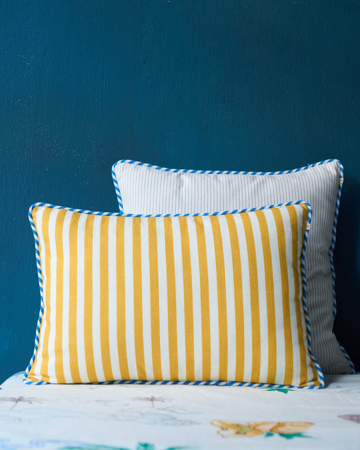 Caravan Cushion Cover in mustard and cream stripes with blue piping.