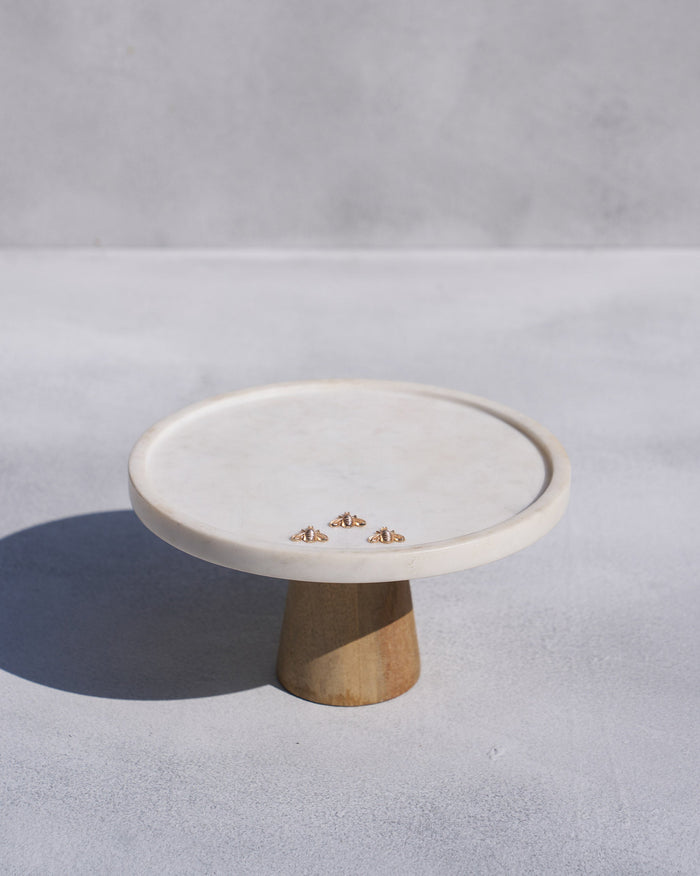 Firefly white cake stand with a wooden base and three small gold bees.