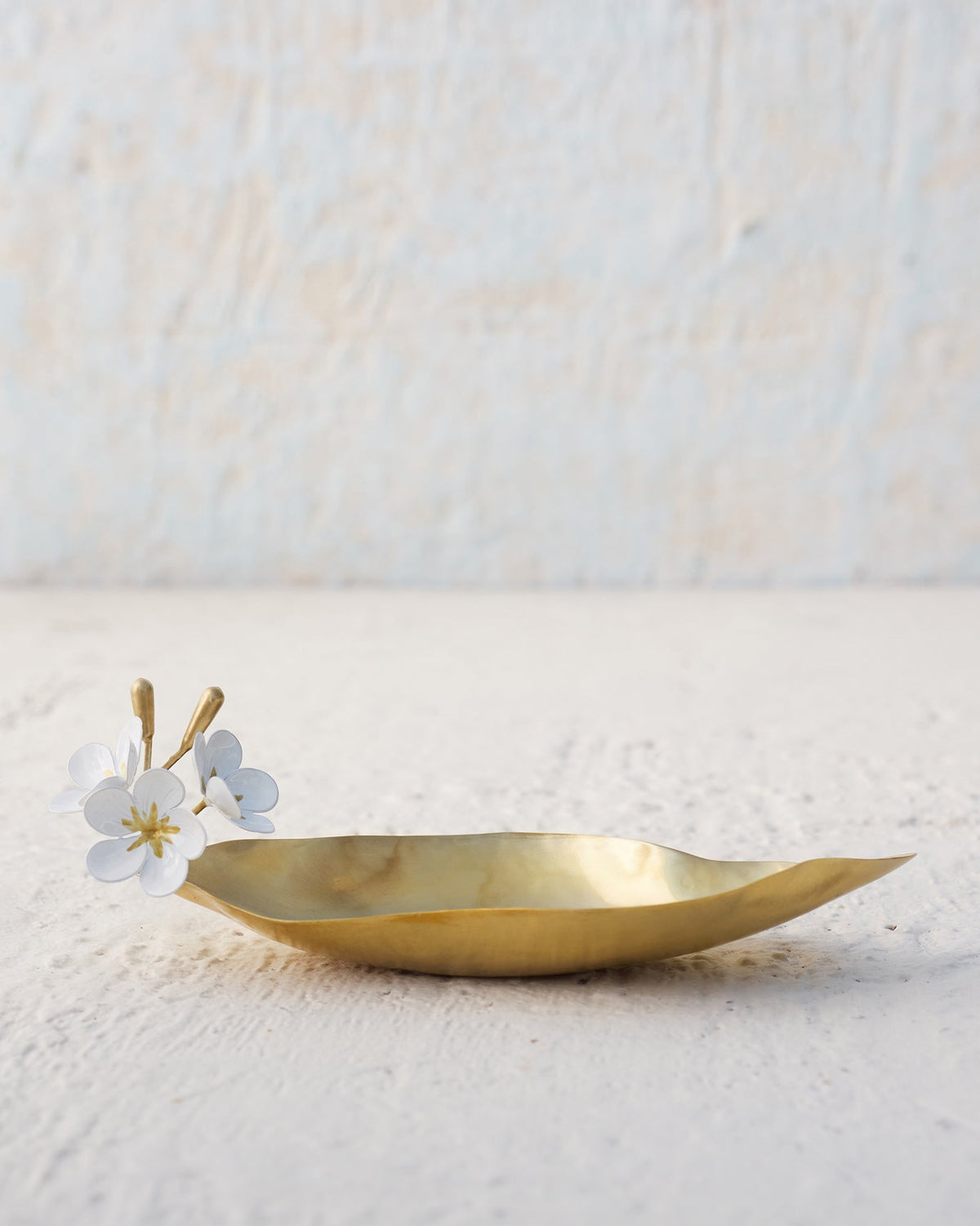 Side view of Champa Trinket Tray with white flowers on one end.