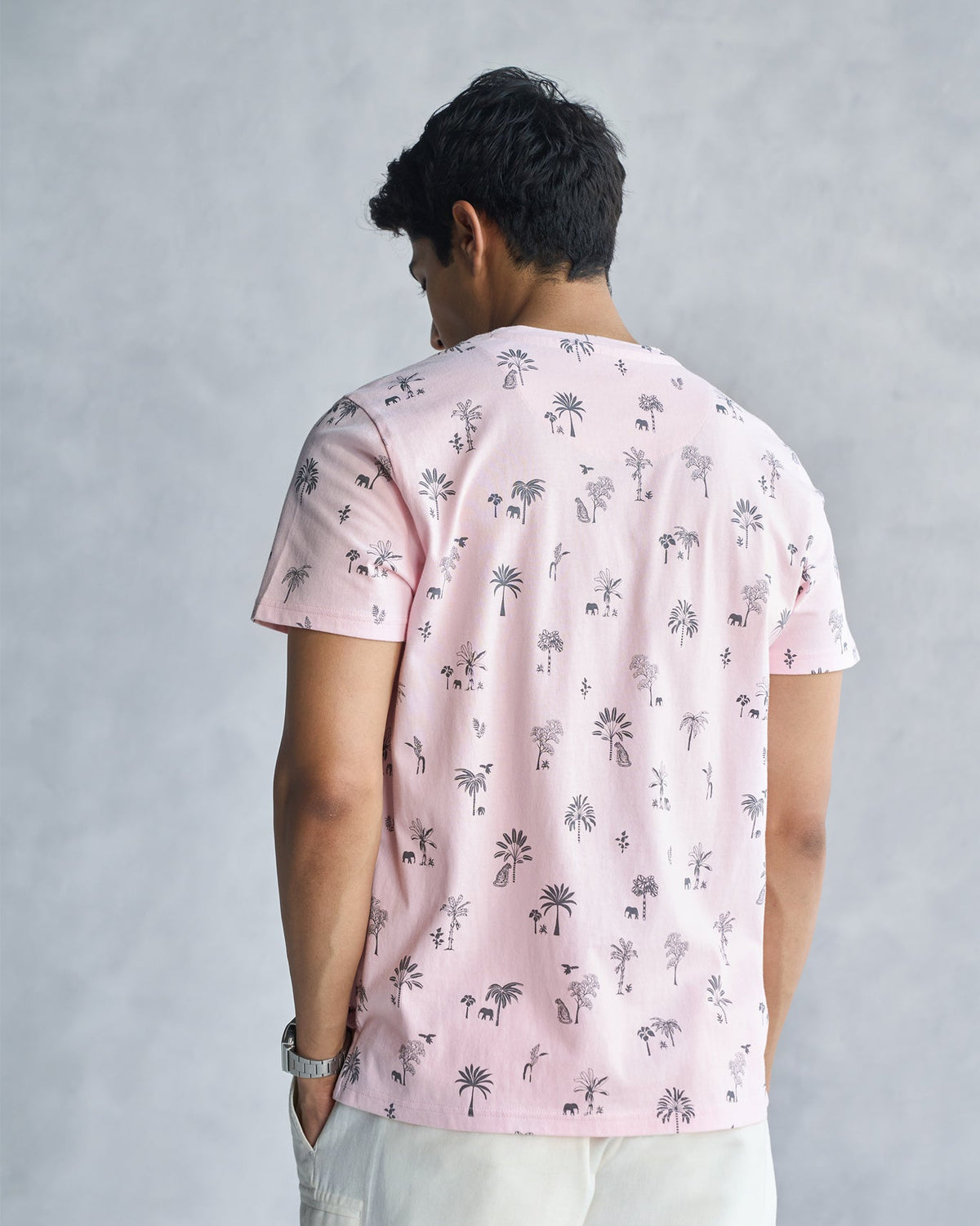 Back of a soft pink Jungle T-shirt worn by a person.