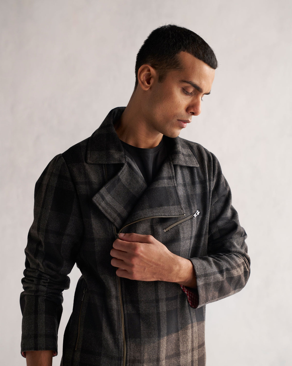 Close-up of the diagonal zip and placket on a black and grey checked Woollen Knotch Collar Jacket.