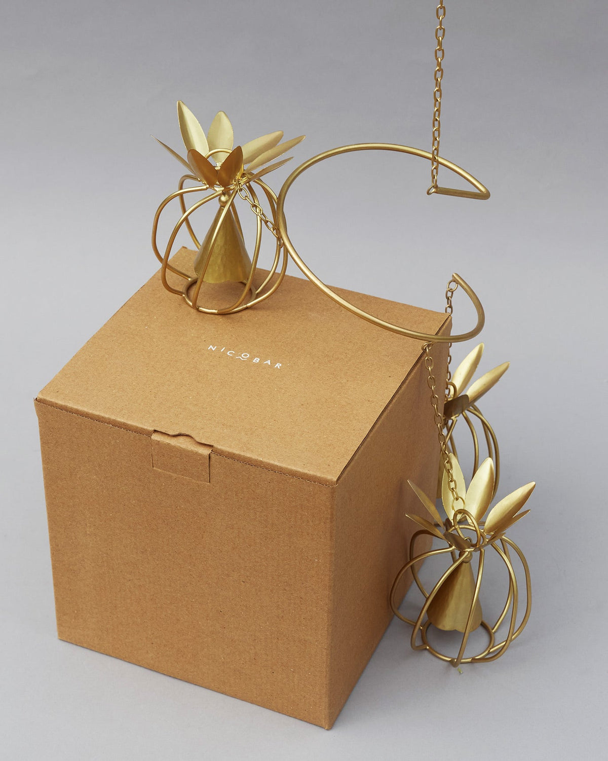 Pineapple wind chime with a kraft Nicobar gift box.