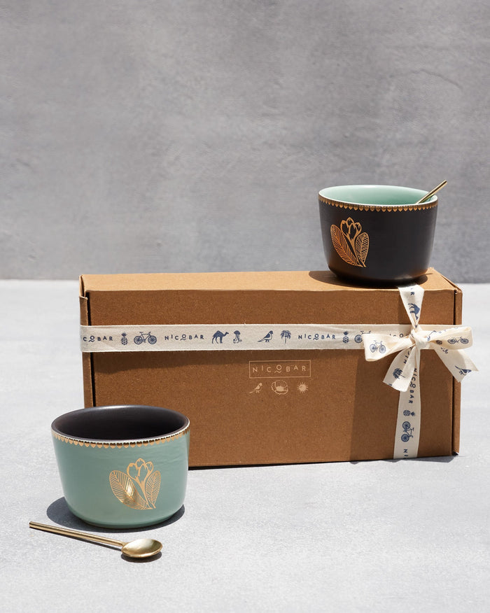 Pair of Frangipani Bowls with Spoons set on a gift box.