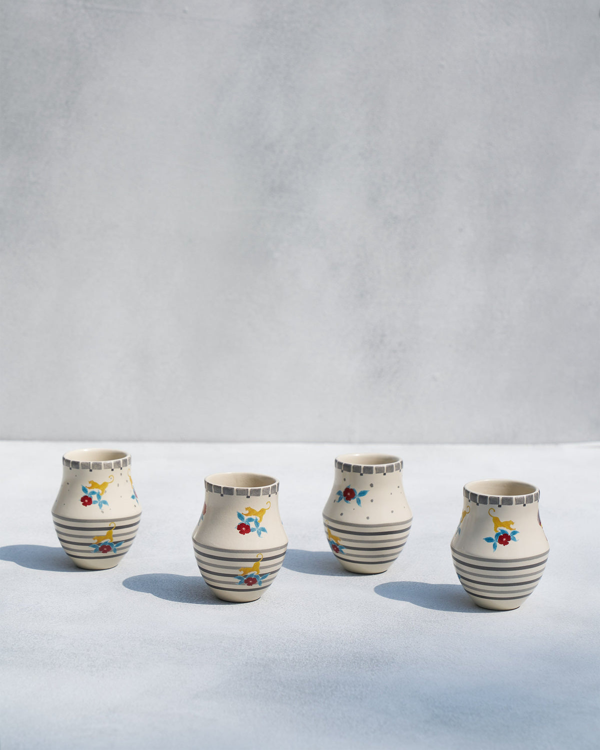 Four Phoenix kulhar cups on a pale surface, seen from the front.