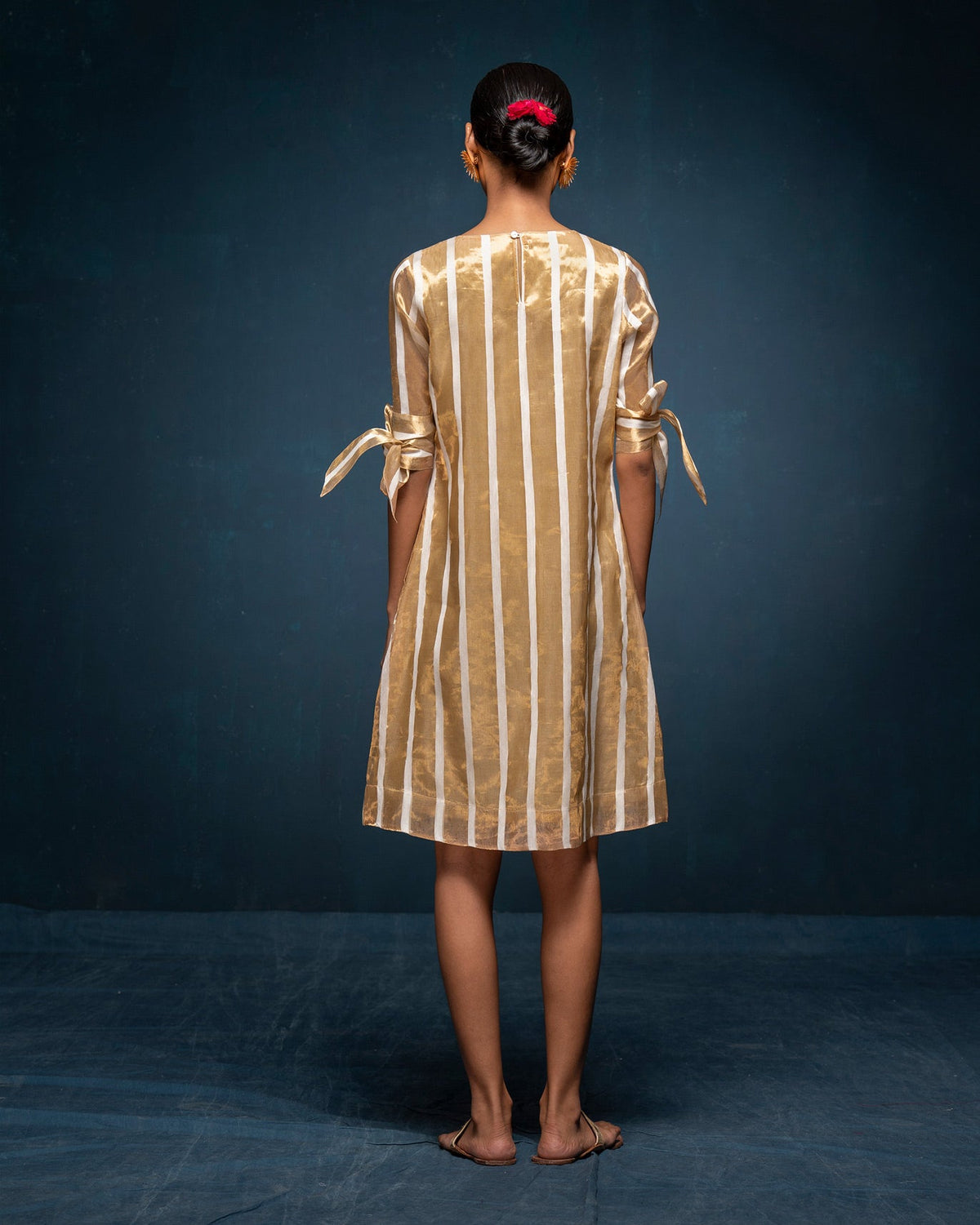 Back of an ivory and gold striped V-Neck Shift Dress worn by a person.