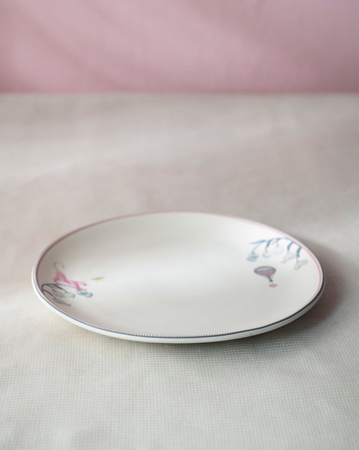 Cream Myra dinner plate with pink animal and hot-air balloon rim motifs.