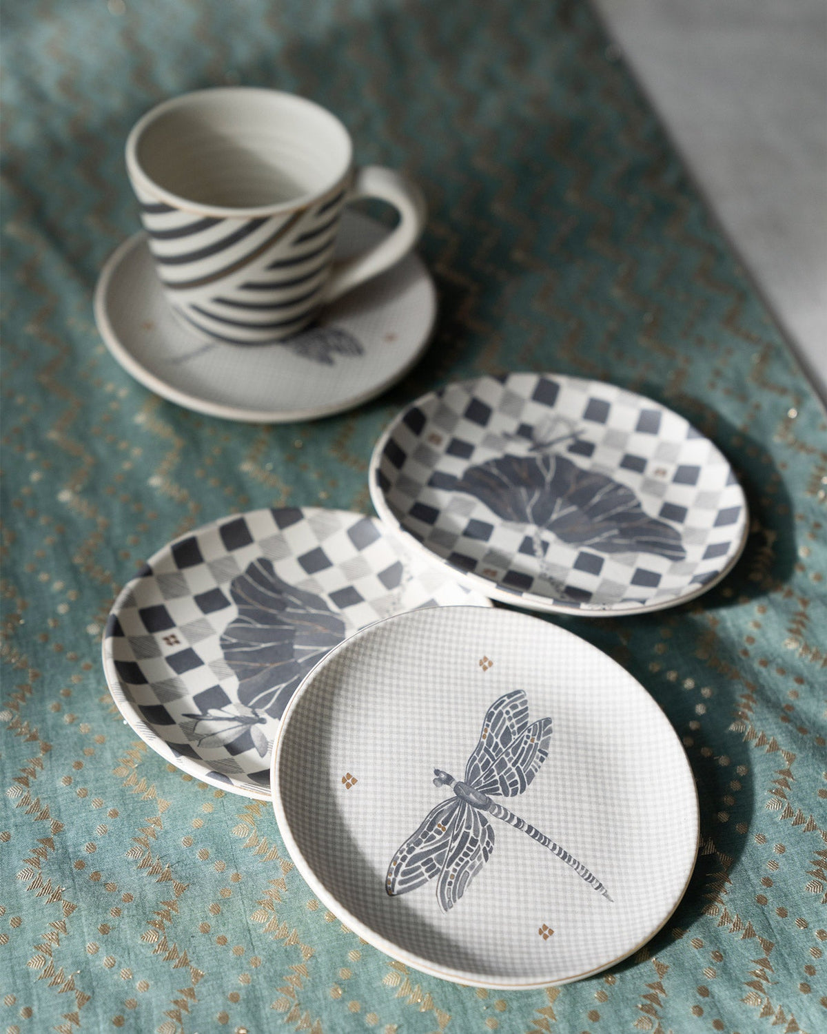 Nectar tea plates in a loose group, one showing a large dragonfly.