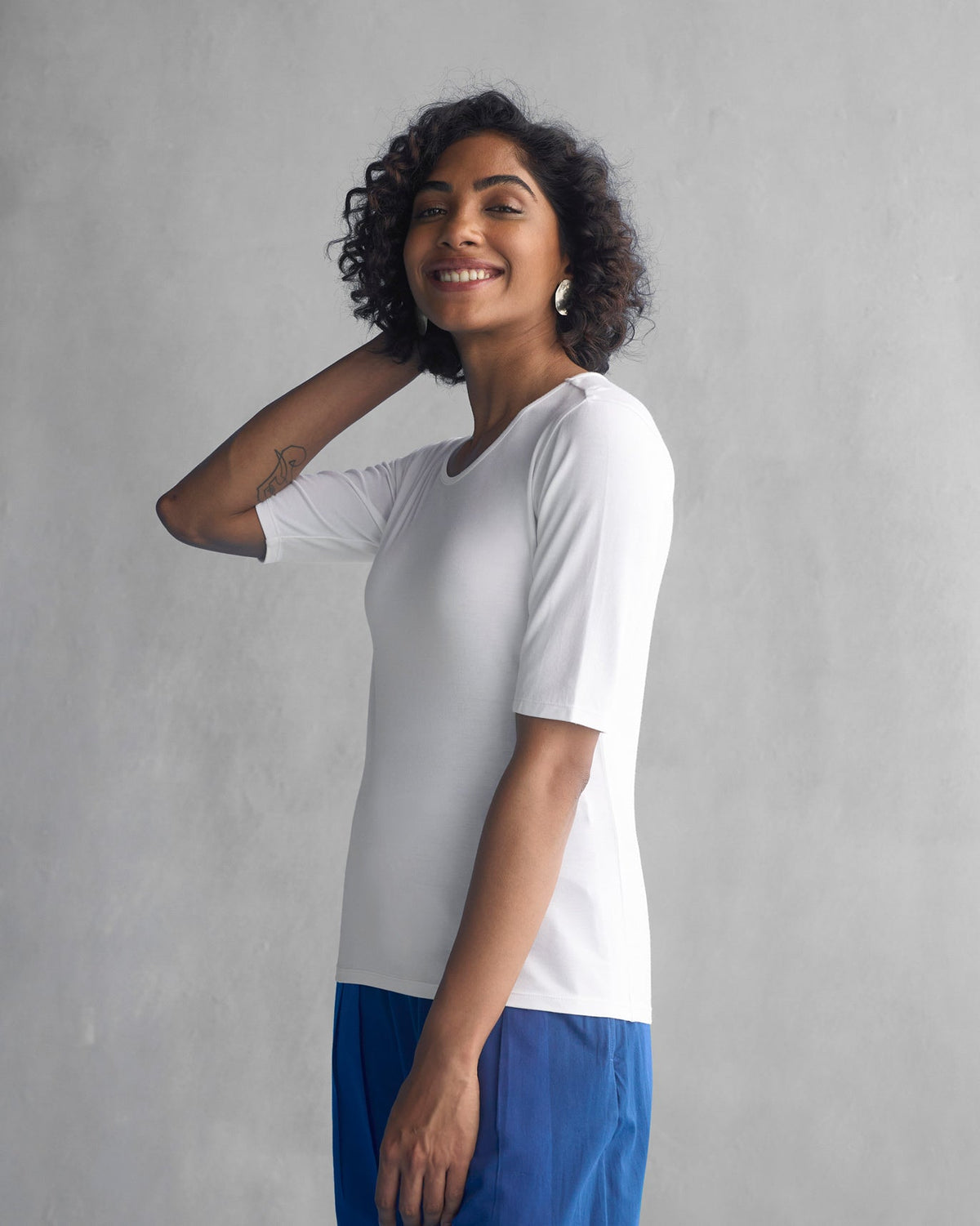 Side view of a white Luna Jersey Top with a fitted silhouette.