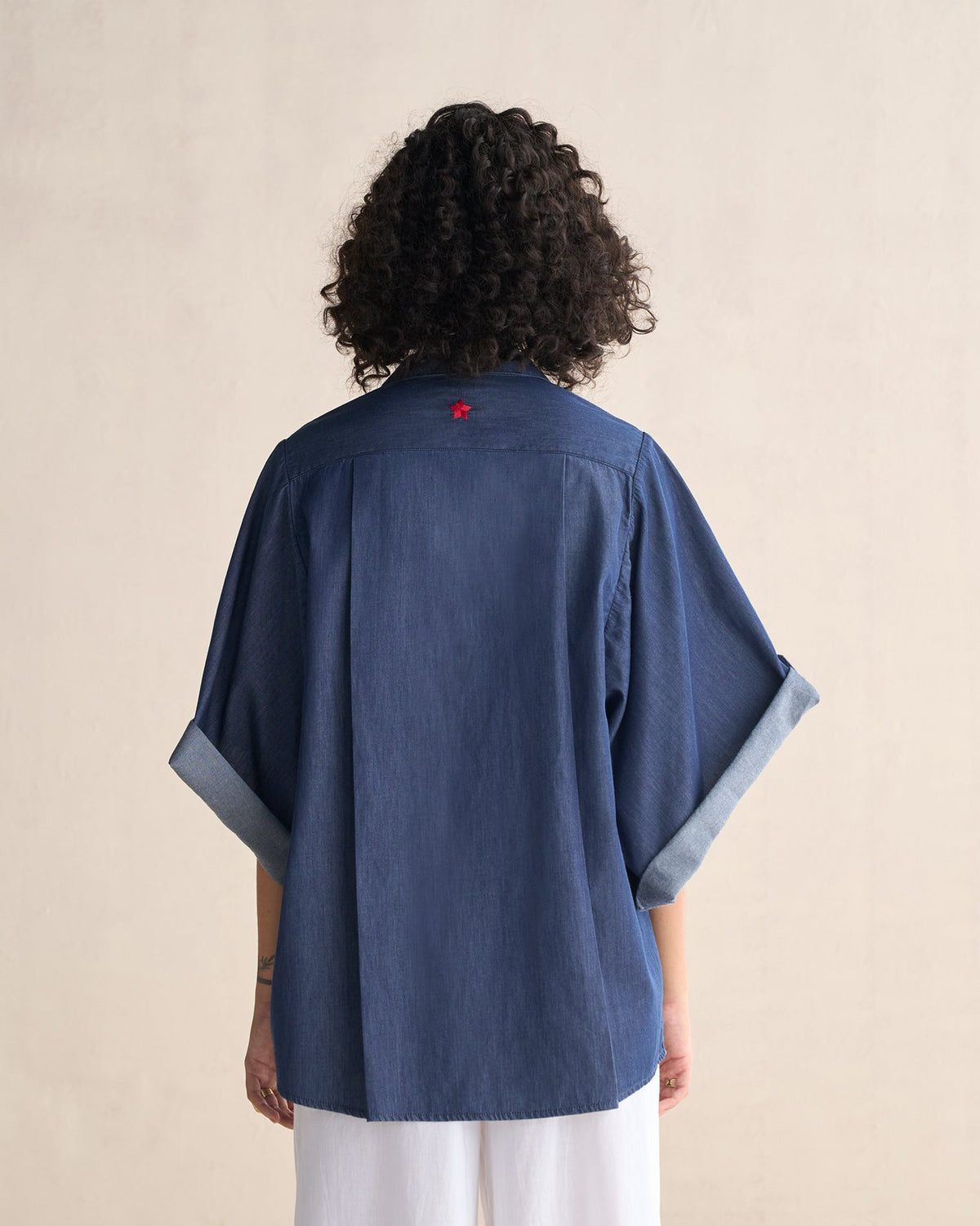 Back of the Drop Armhole Shirt with a small red star at the yoke, worn by a person.
