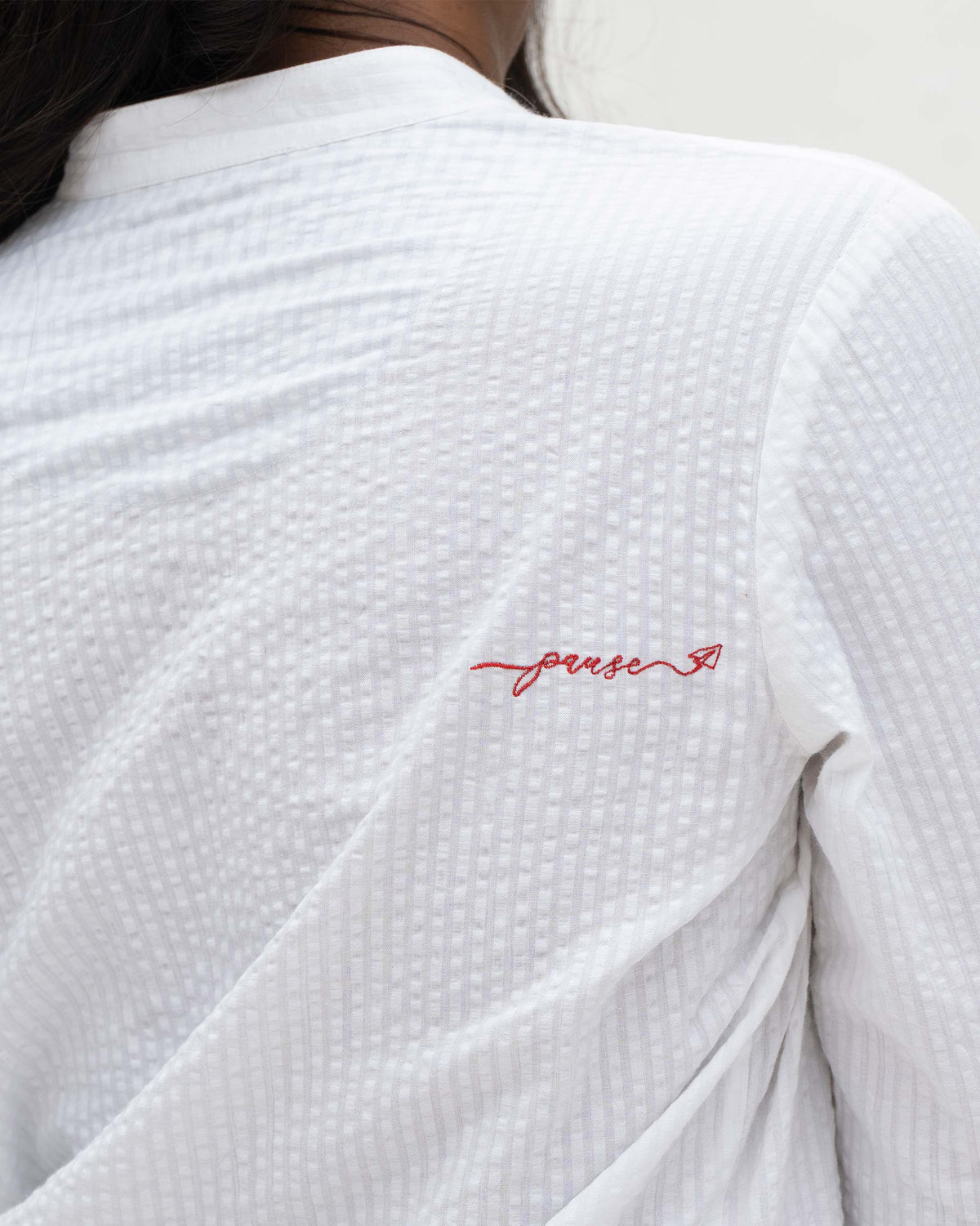 Close-up of the back of a white Basic Long Length Kurta showing red script embroidery.