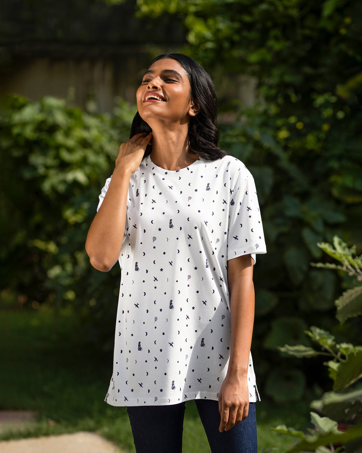 Person wearing a longer white Up and Away T-Shirt with a navy print.