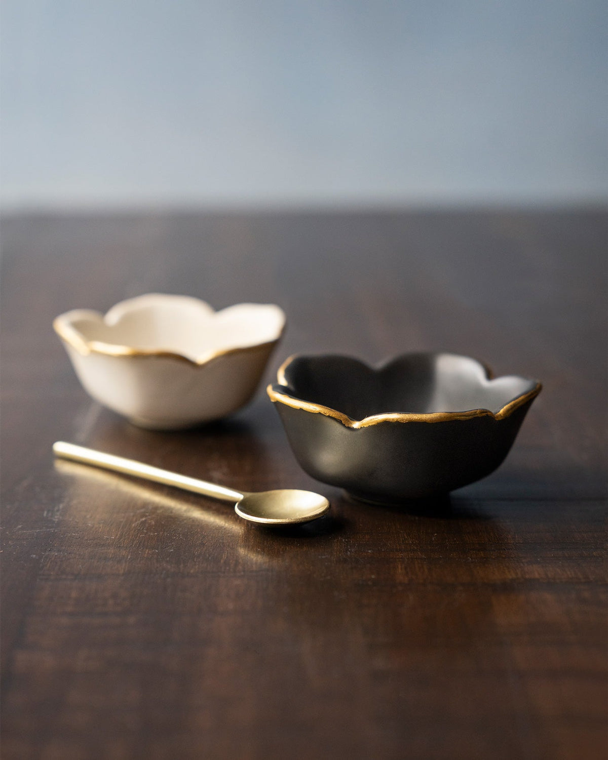 Pair of Lotus Trinket Trays, one white and one black, with gold rims.