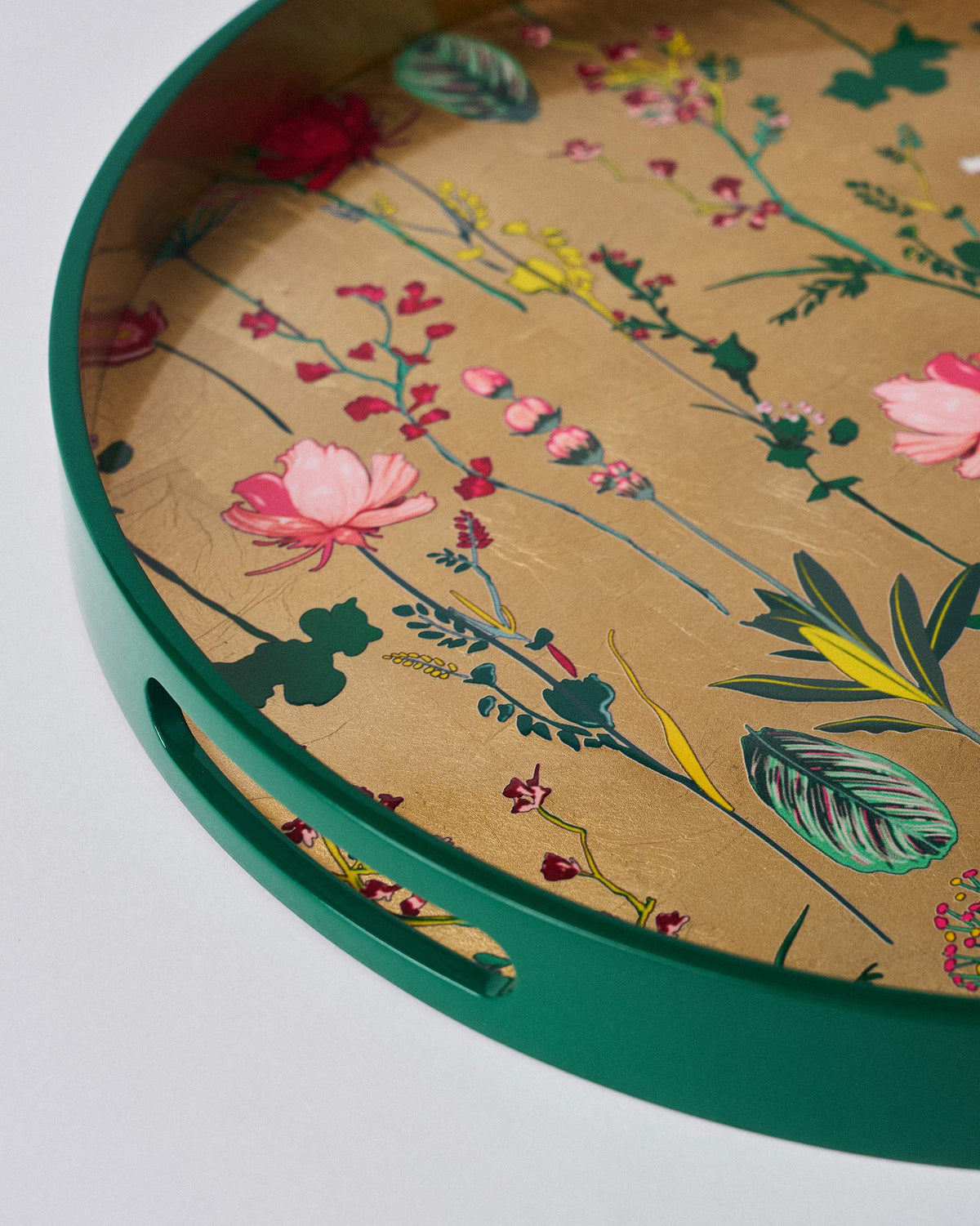 Close-up of the Mahi Round Tray showing its green rim, handle cut-out and floral print.