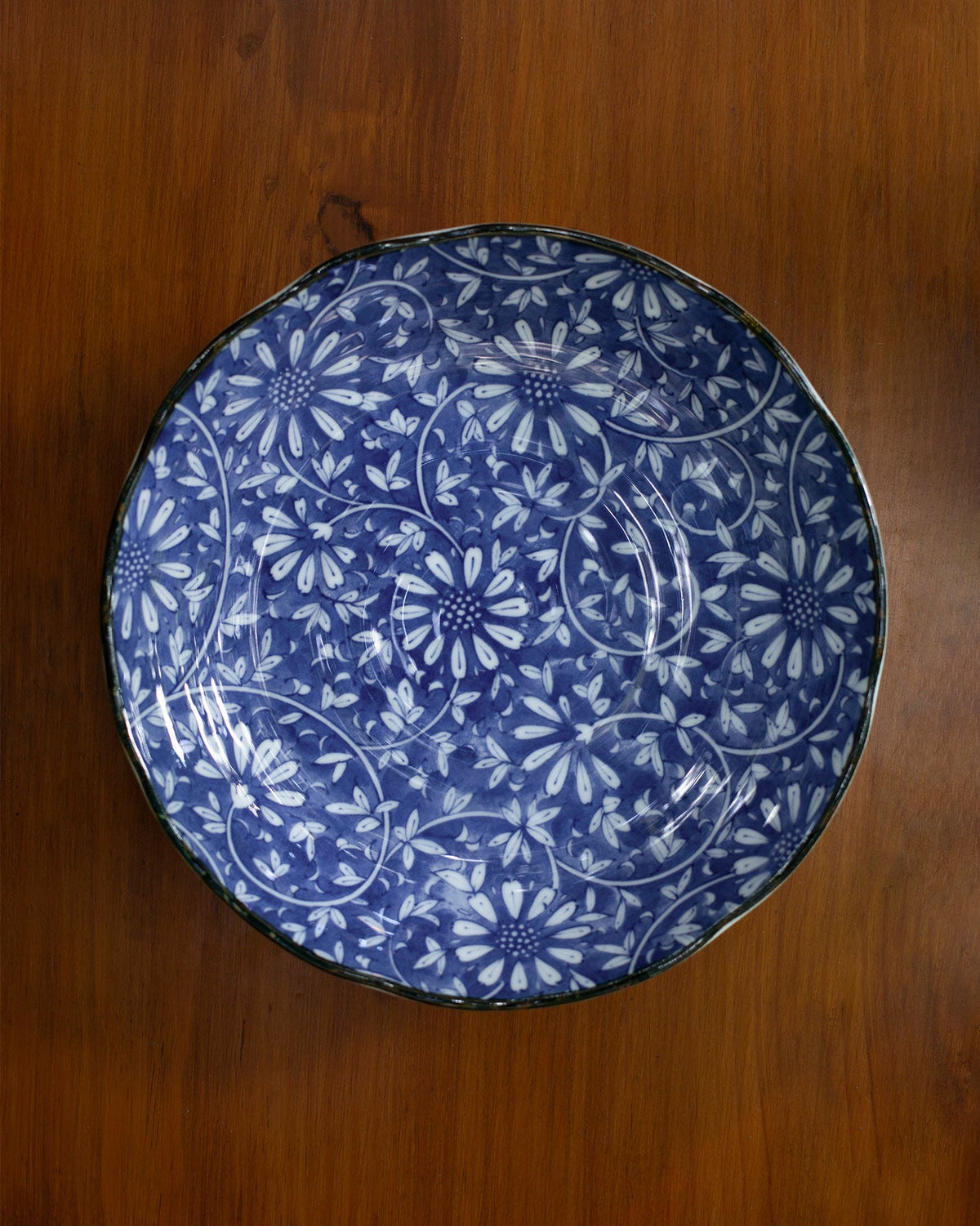 Top-down view of the Aika Shallow Bowl showing its blue and white floral pattern.