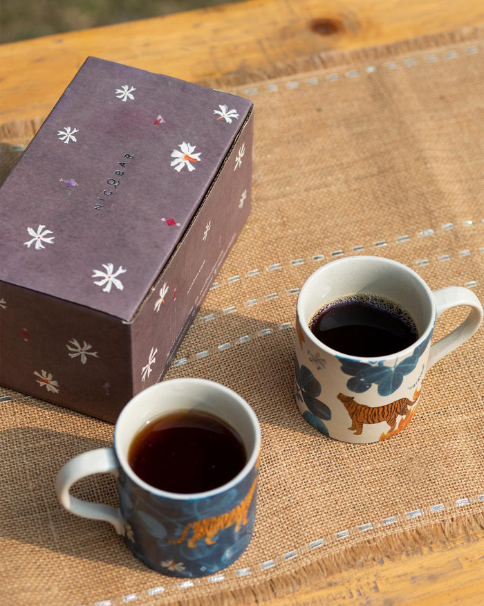 Pair of Nadi straight mugs with tiger prints beside a Nicobar gift box.