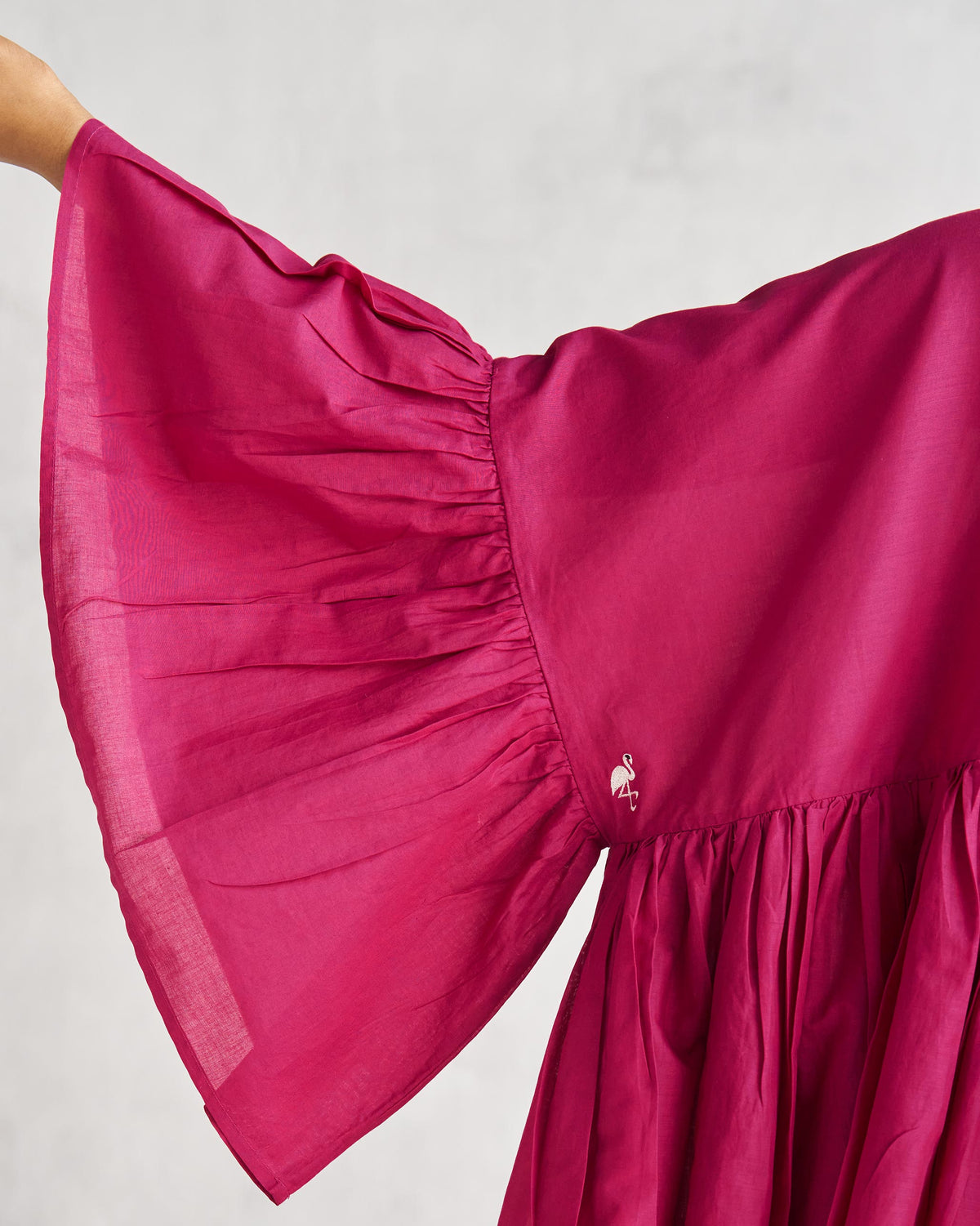 Close-up of a berry Frill Top sleeve showing gathers and a small bird at the seam.