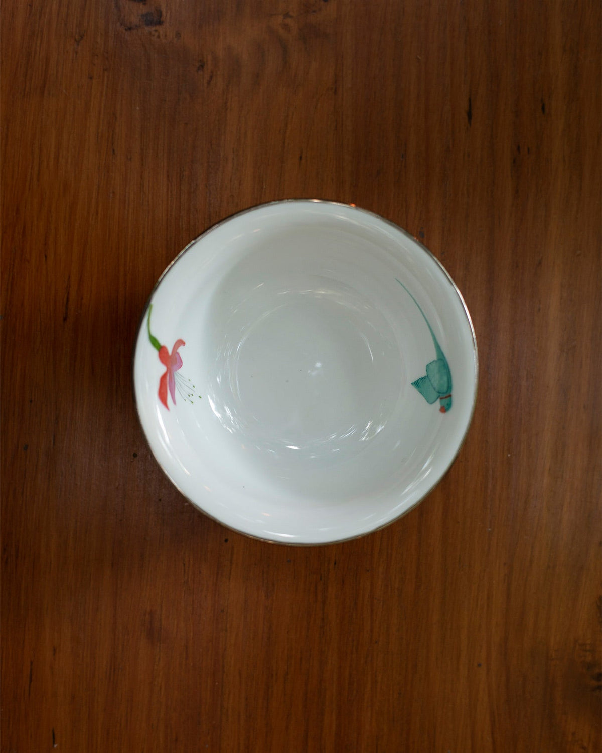 Overhead view of Botanical Katori with a red flower and green detail inside.