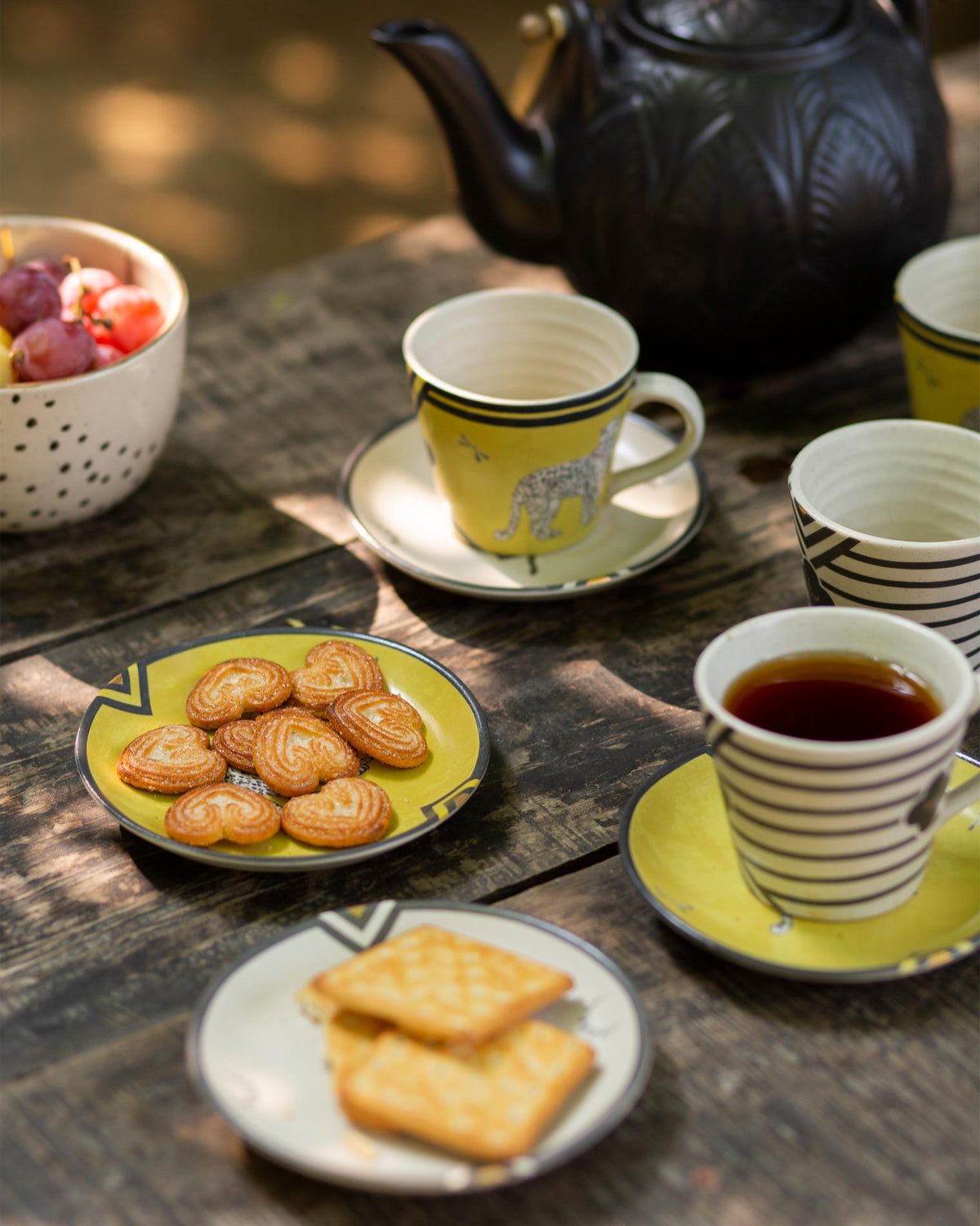 Yellow Leopard Tea Plate with a leopard motif, shown on a wooden table.