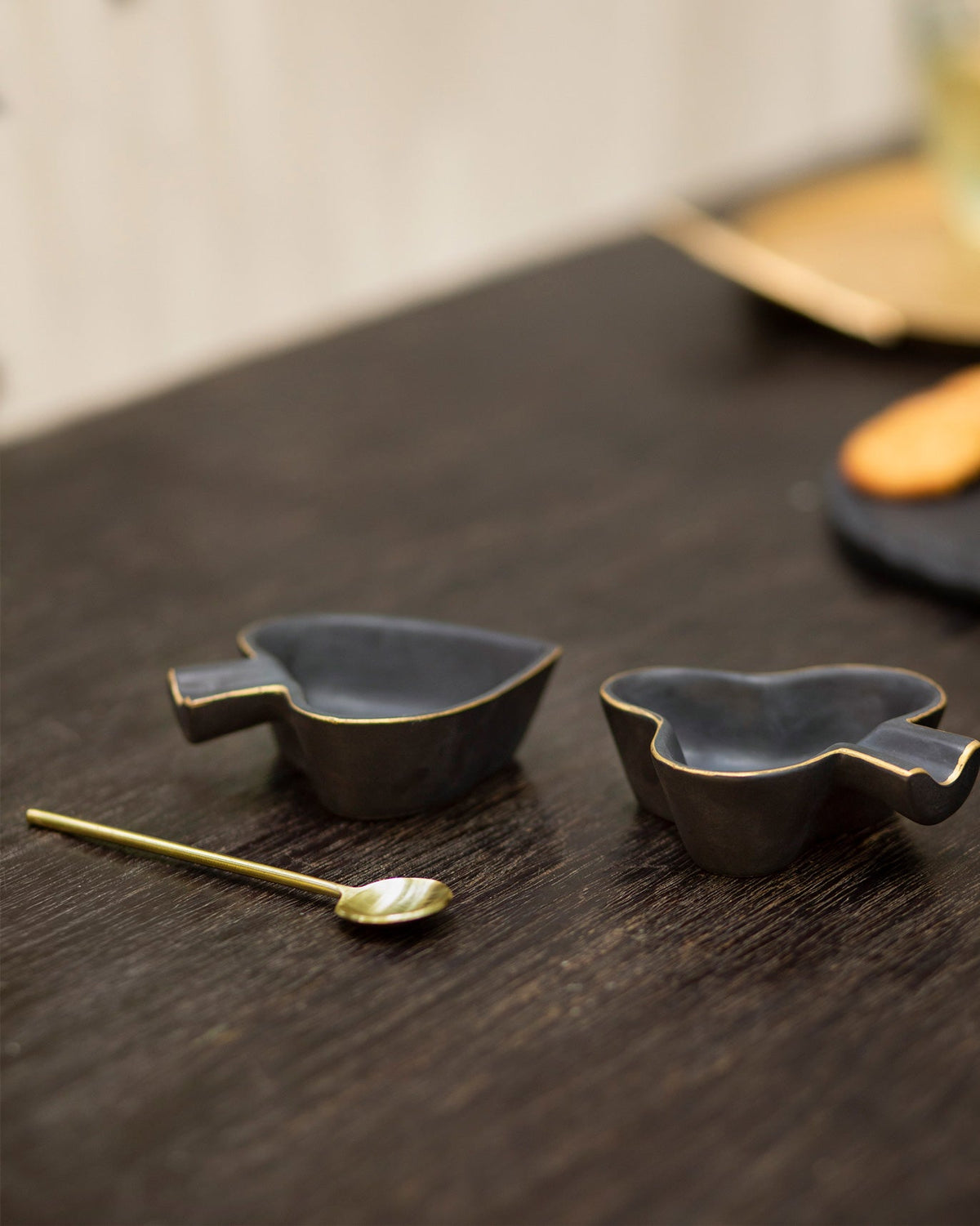 Pair of Club & Spade Trinket Dishes with a gold spoon on a table.