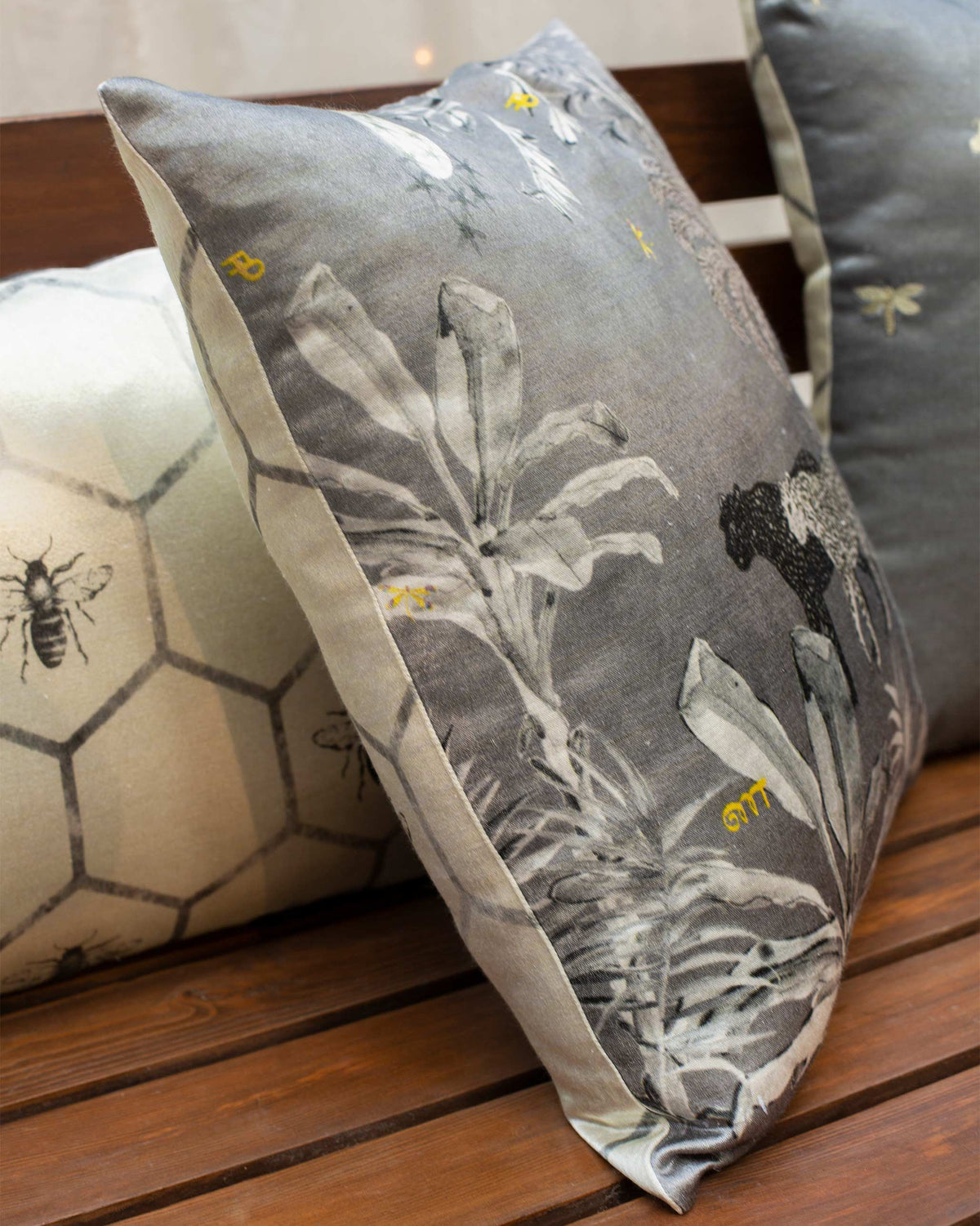 Side angle of the Leopard Twilight Cushion Cover showing leaf and leopard prints.