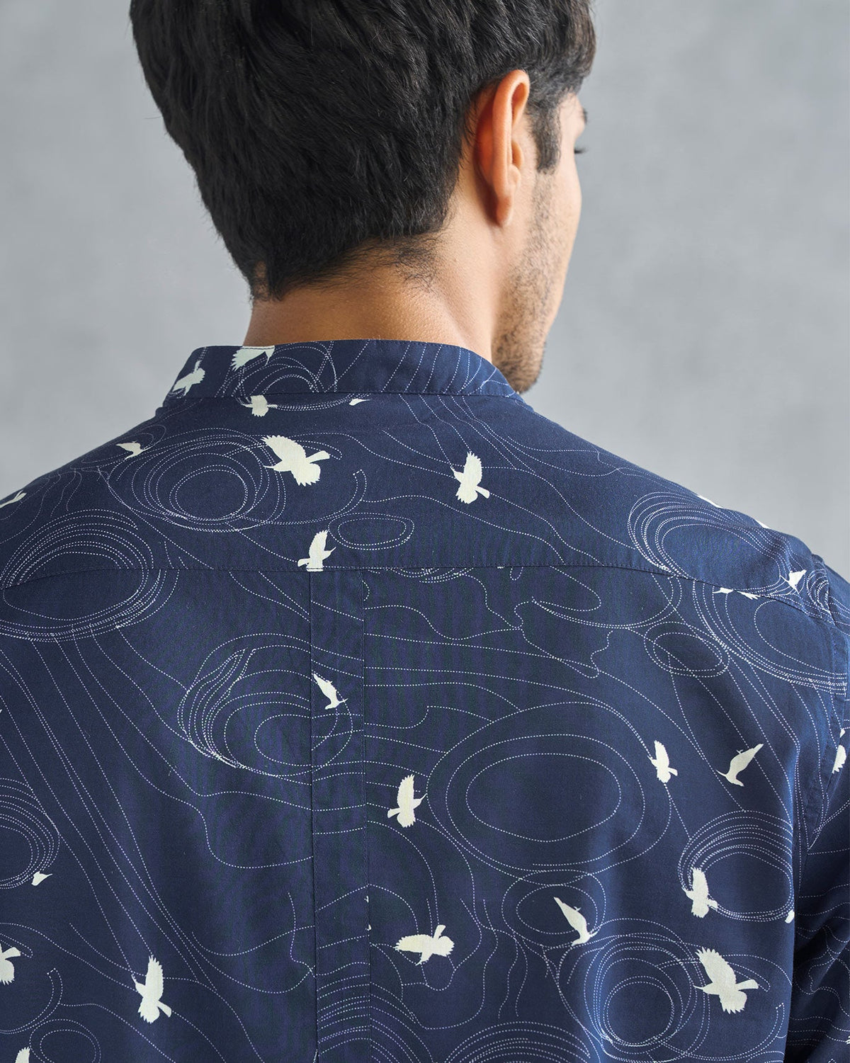Close-up of the back yoke of a deep navy Nawab shirt showing white birds.