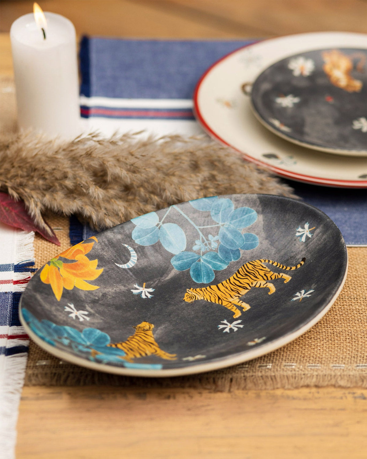 Nadi Oval Platter on a table, showing tigers and orange flowers on its dark surface.