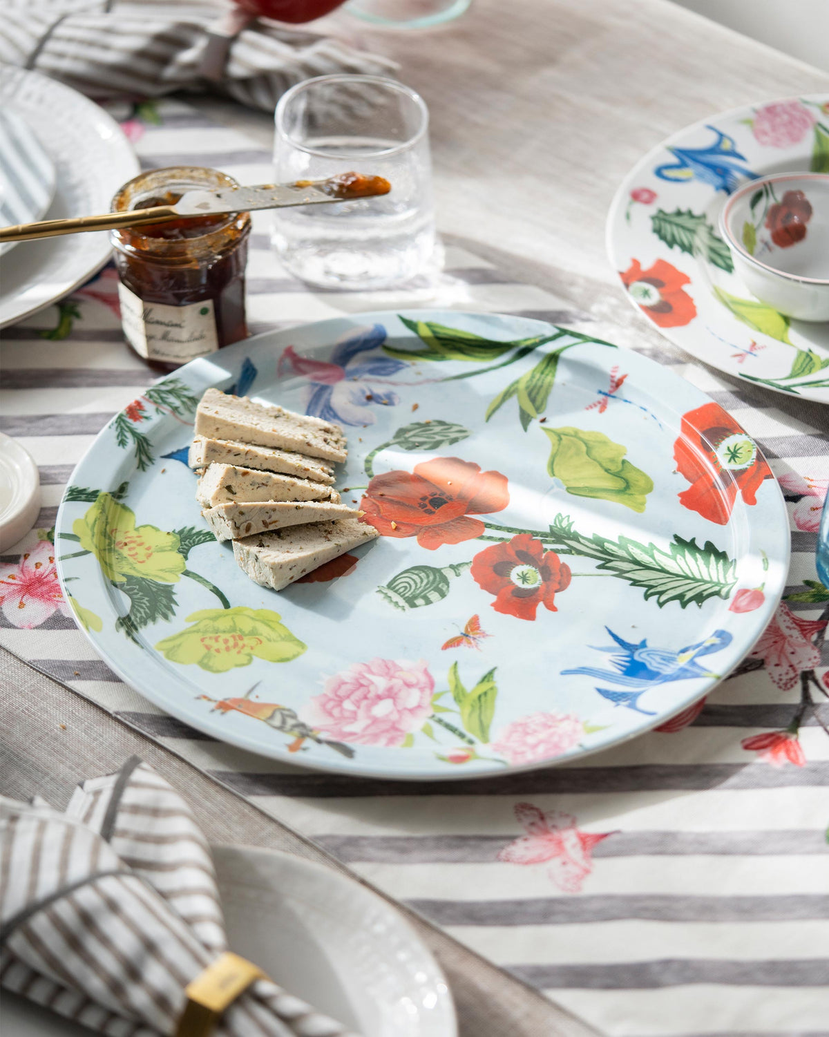 Wildflower Platter with red poppies and a blue bird, holding slices of food.