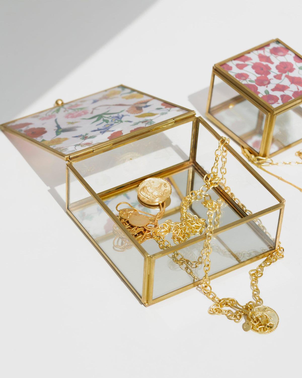 Open Wildflower Jewellery Box holding gold chains and a locket.