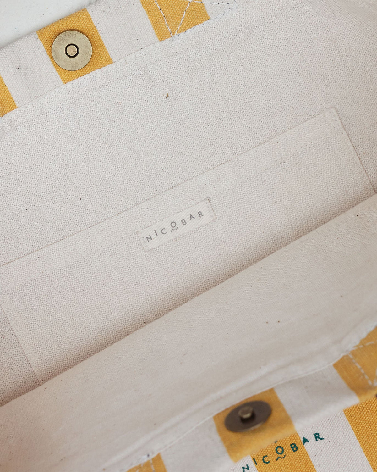 Interior of a Bagan Stripe Tote with an ivory lining and a Nicobar label.