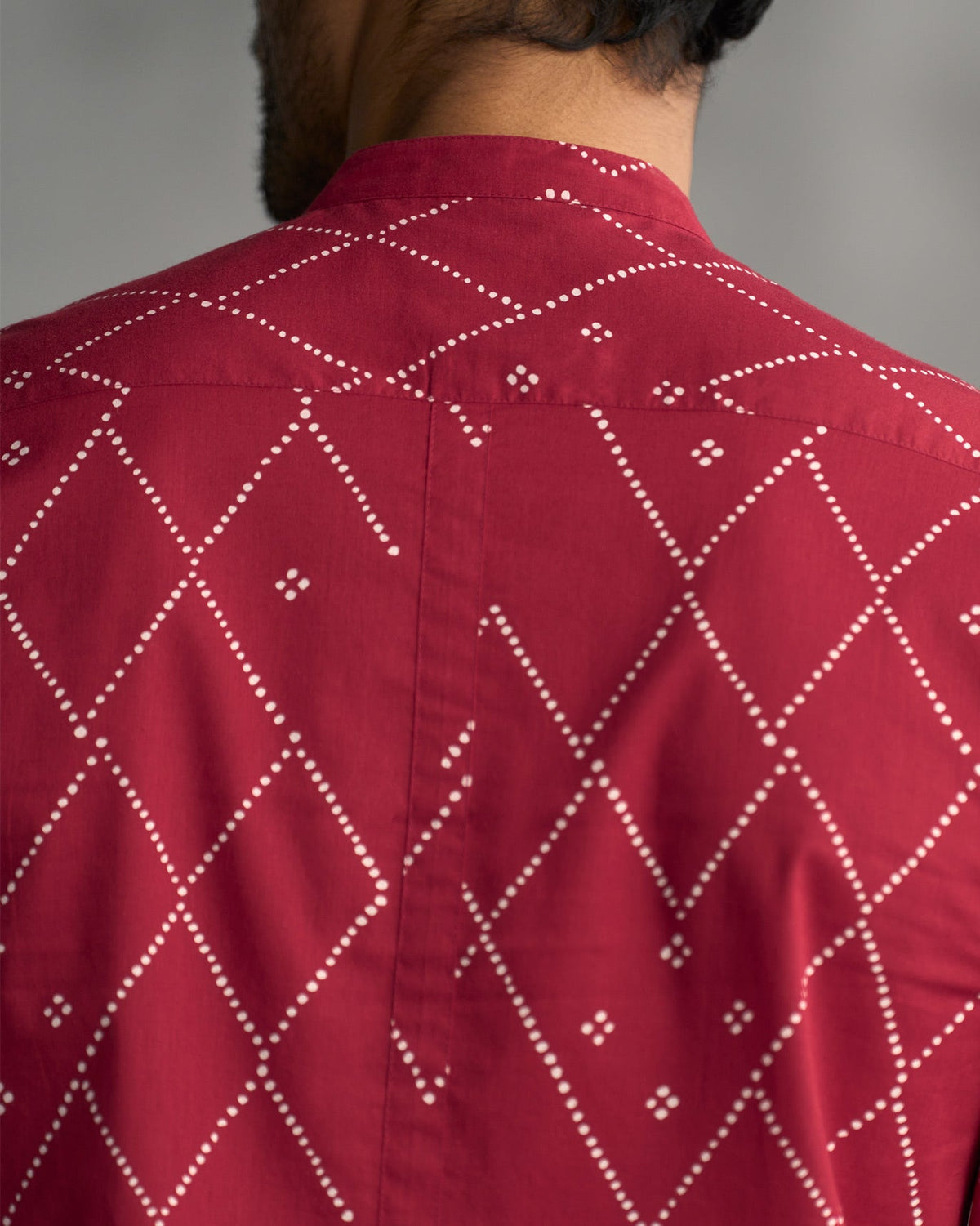 Close-up of the back yoke of a red Nawab shirt with white dotted print.