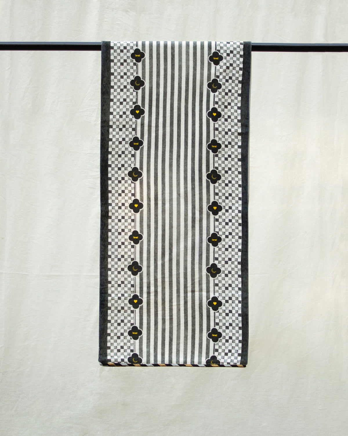 Midnight Runner hanging against a white backdrop, with black clover motifs and stripes.