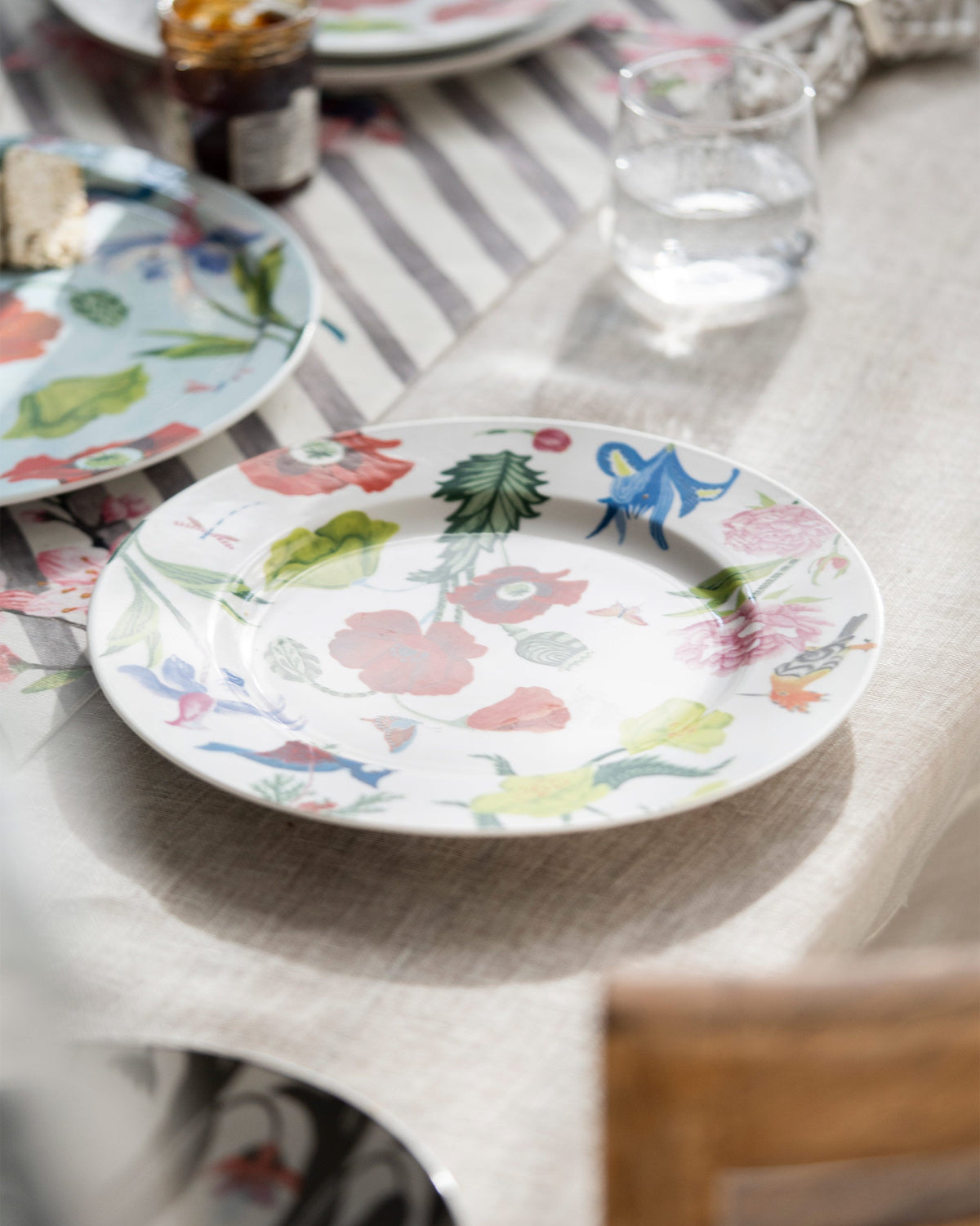 Wildflower Dinner Plate set on a table with other plates nearby.