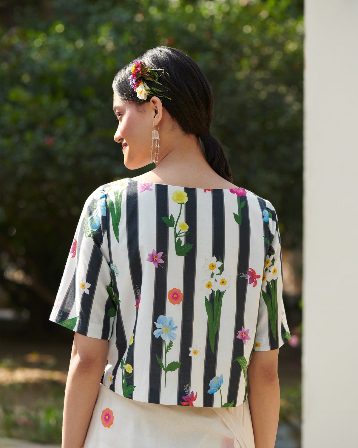 Back of black and white striped Boat Neck Blouse worn by a person.