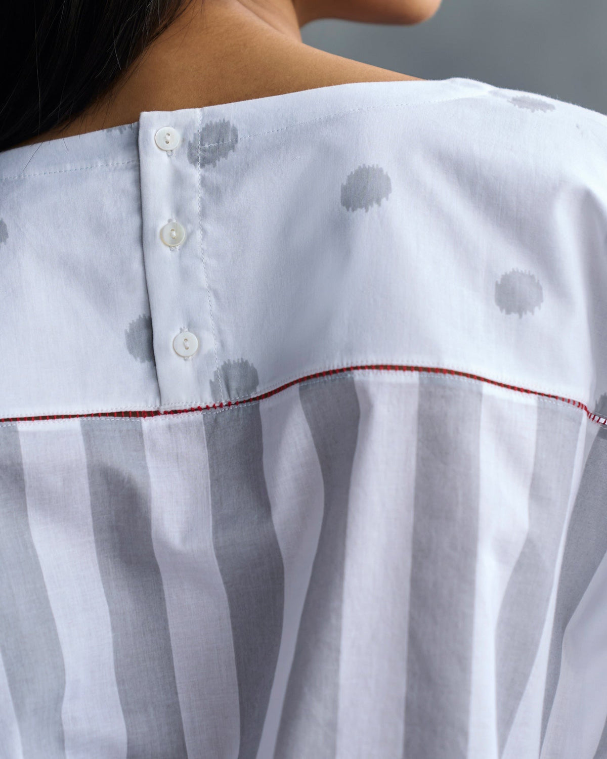 Close-up of the Back Fagotting Top yoke with buttons and red piping.