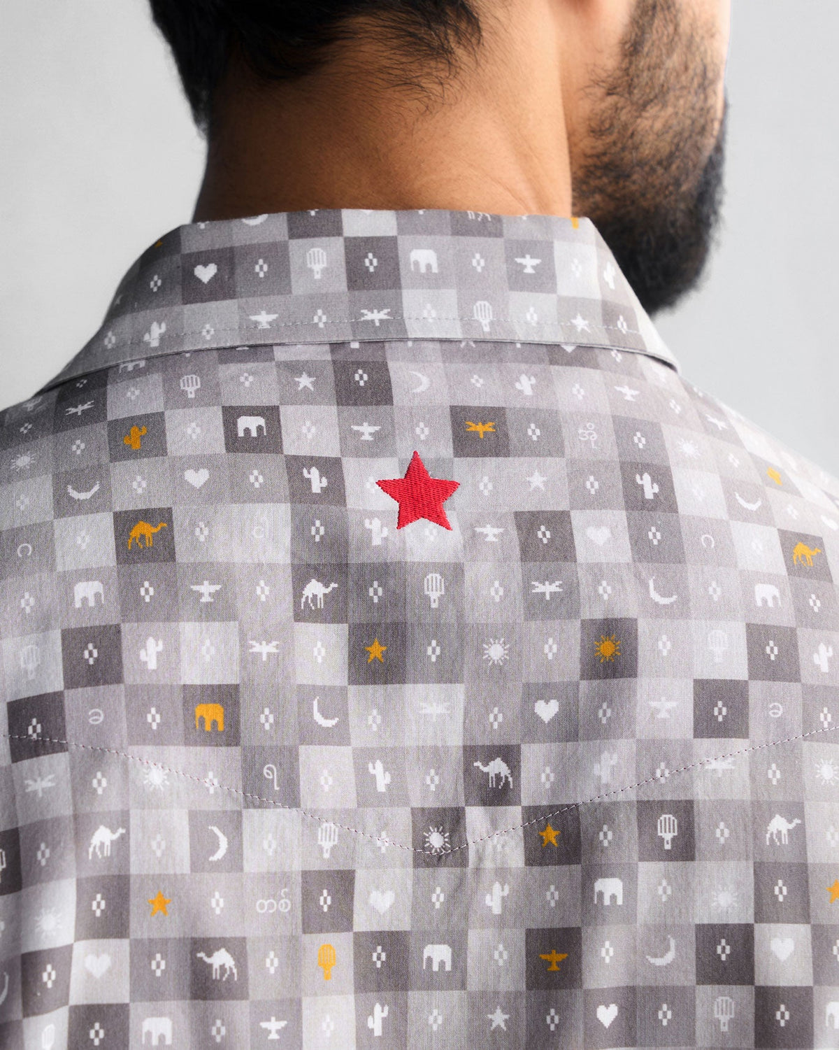Close-up of the back yoke of a grey Pocket Shirt with a red star embroidery.