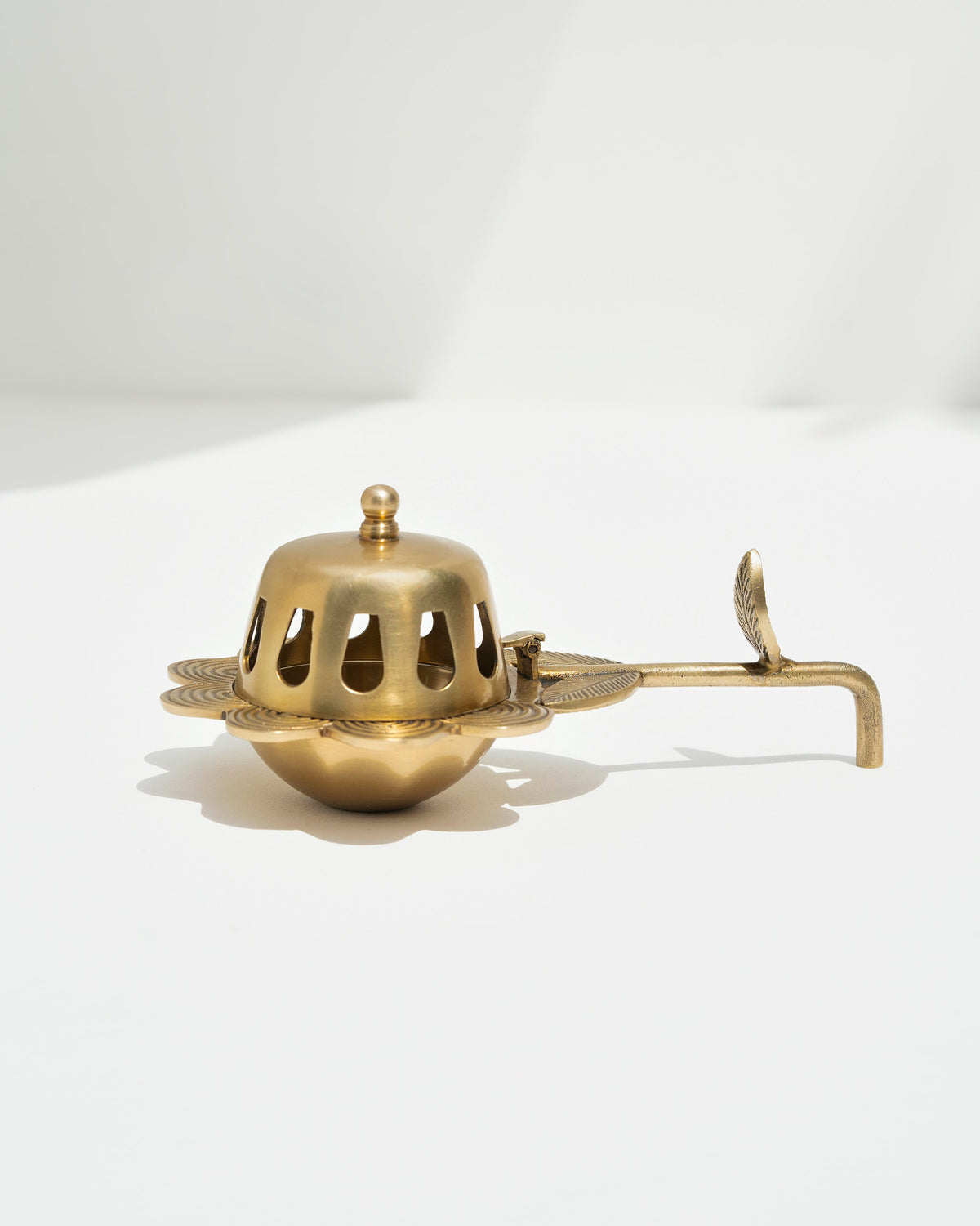Side view of the Alpine Dhuna in brass with its pierced dome and handle.