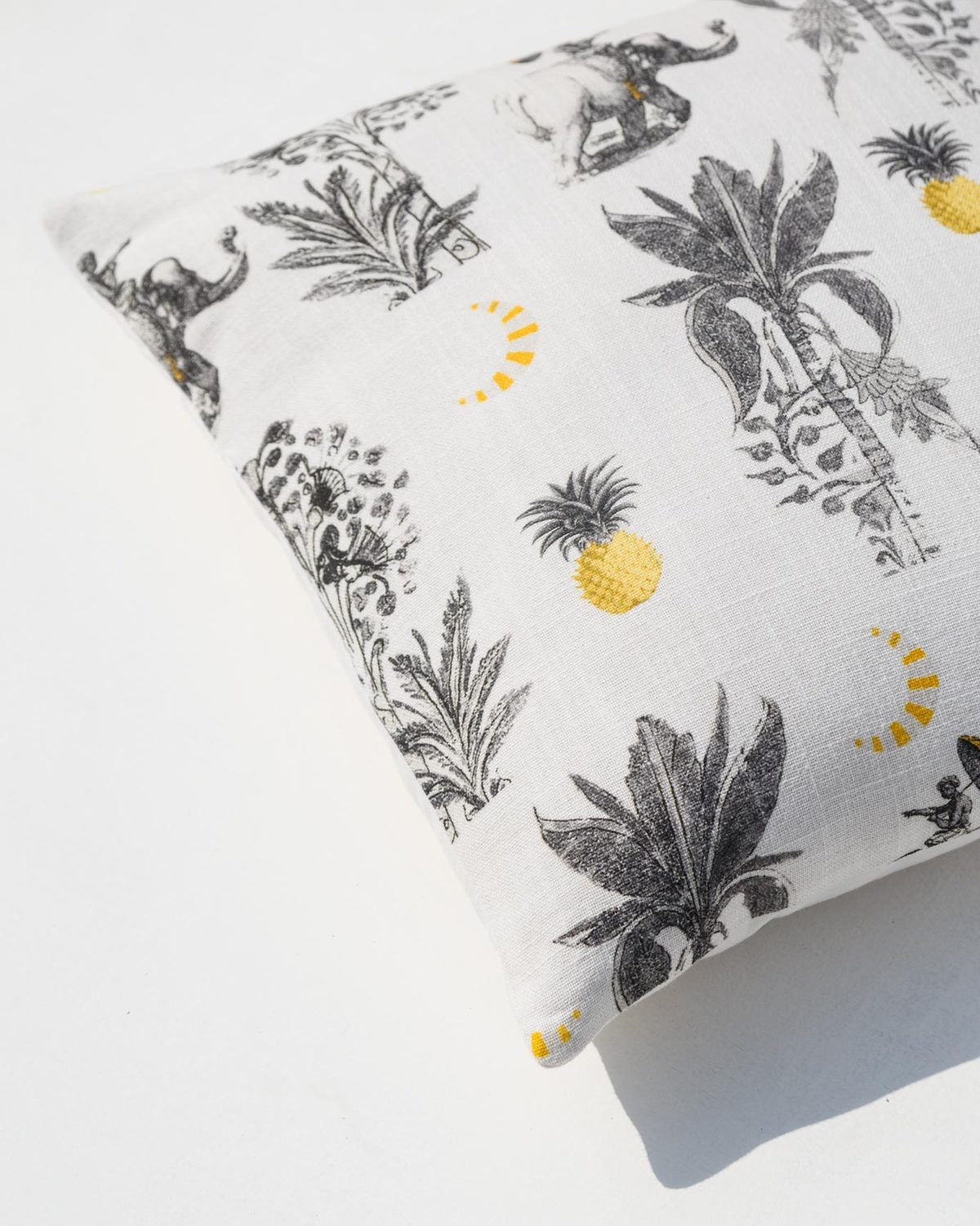 Close-up of the Bentota Cushion Cover showing printed palms and pineapples.