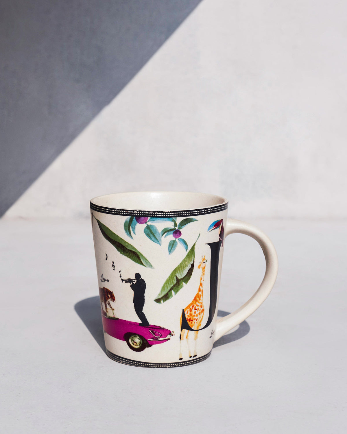 Side view of Jungle mug showing a pink car and a giraffe.