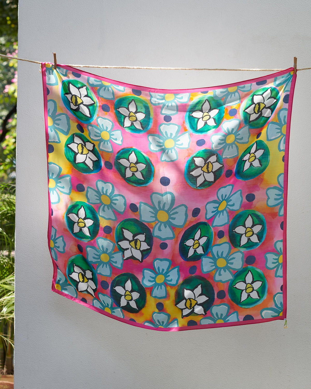 Meadow Scarf hung flat, printed with green-centred white flowers and pale blue blooms.
