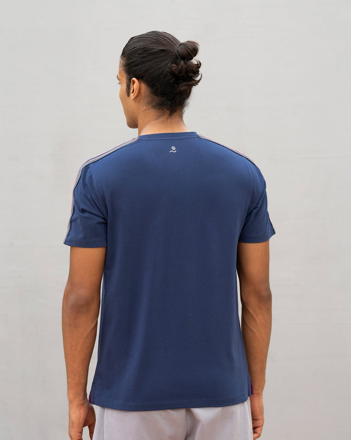 Back of a navy Nico crew neck t-shirt worn by a person.