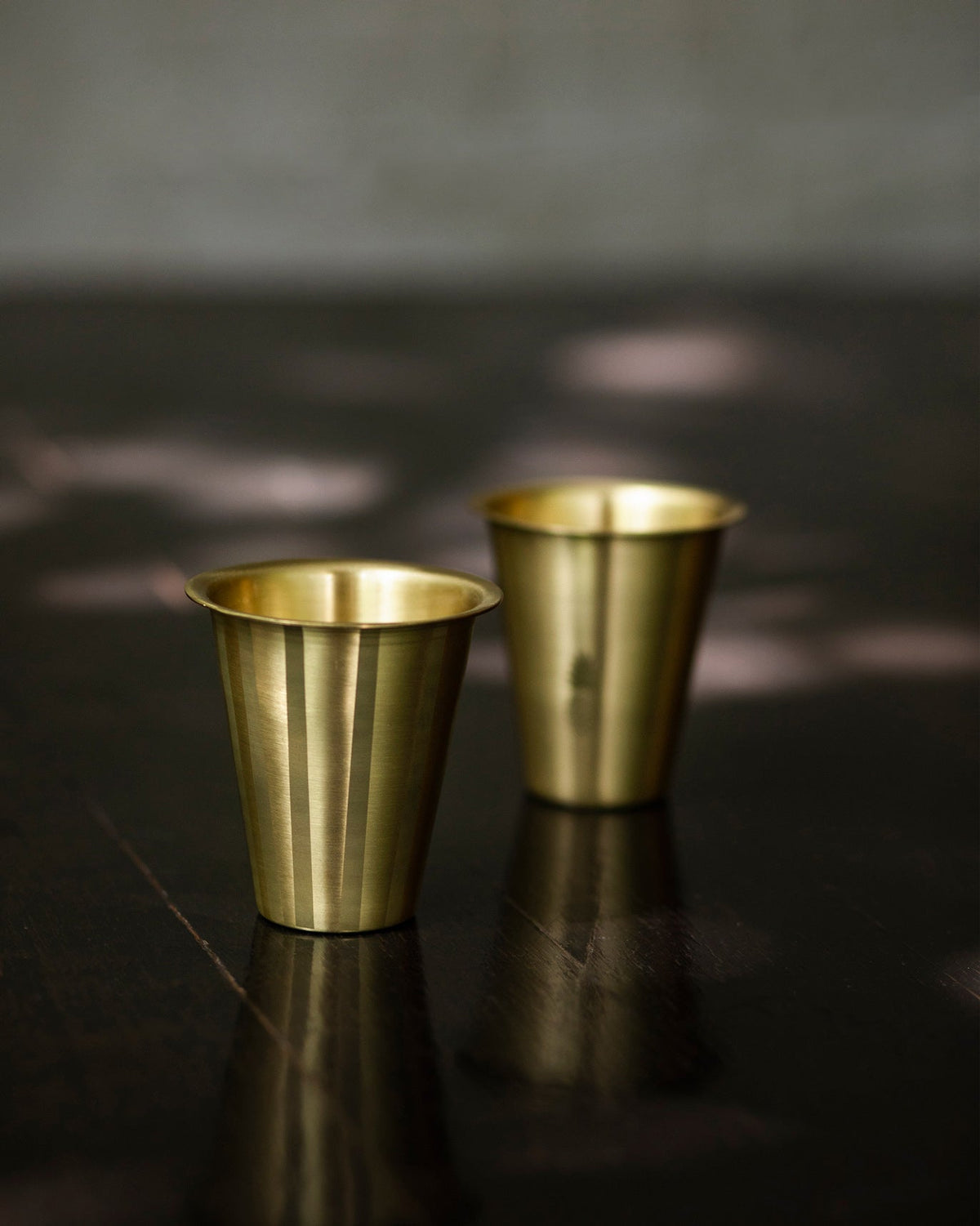 Pair of Dariya Tumblers standing on a dark table.